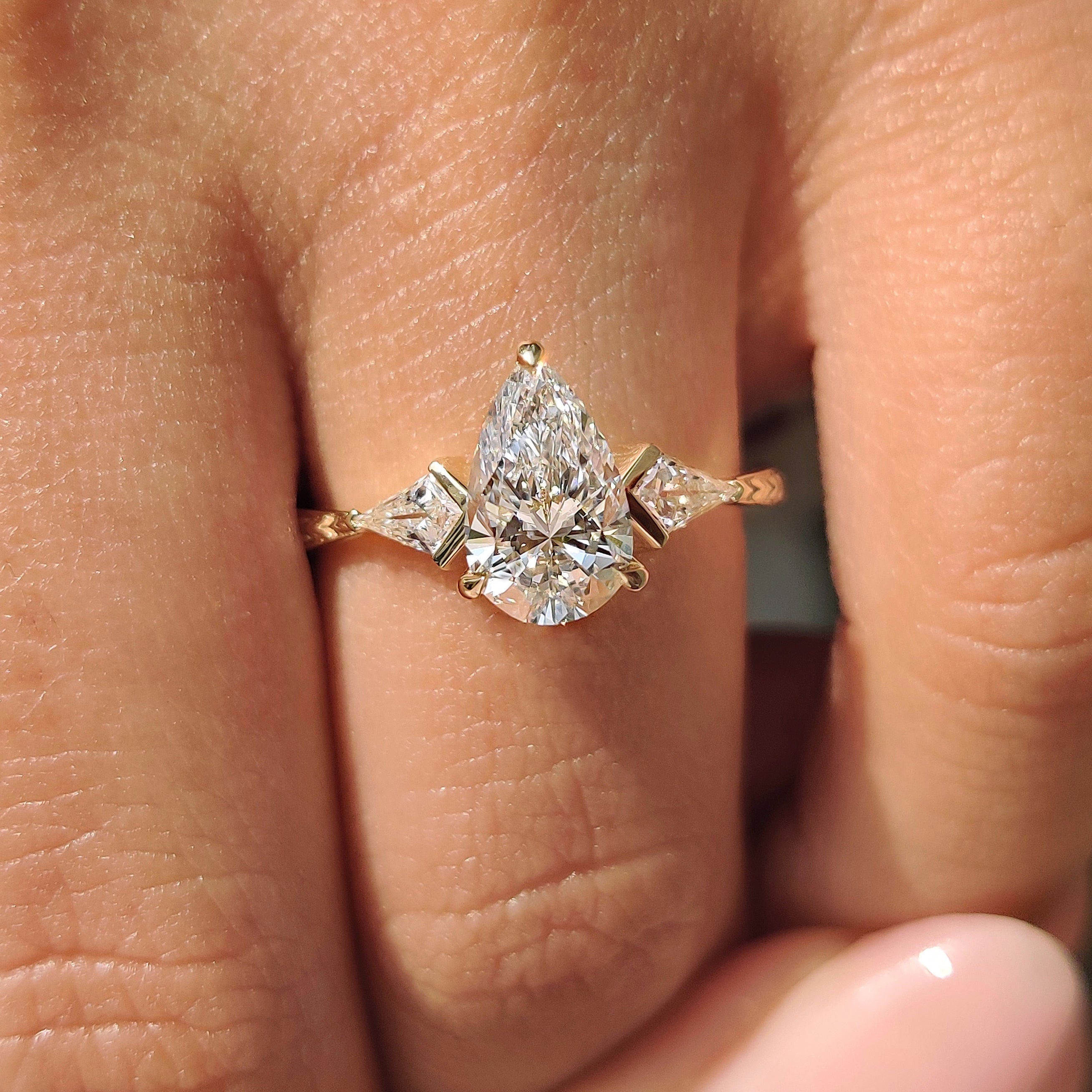 Three stone diamond ring with tapered shank design.
