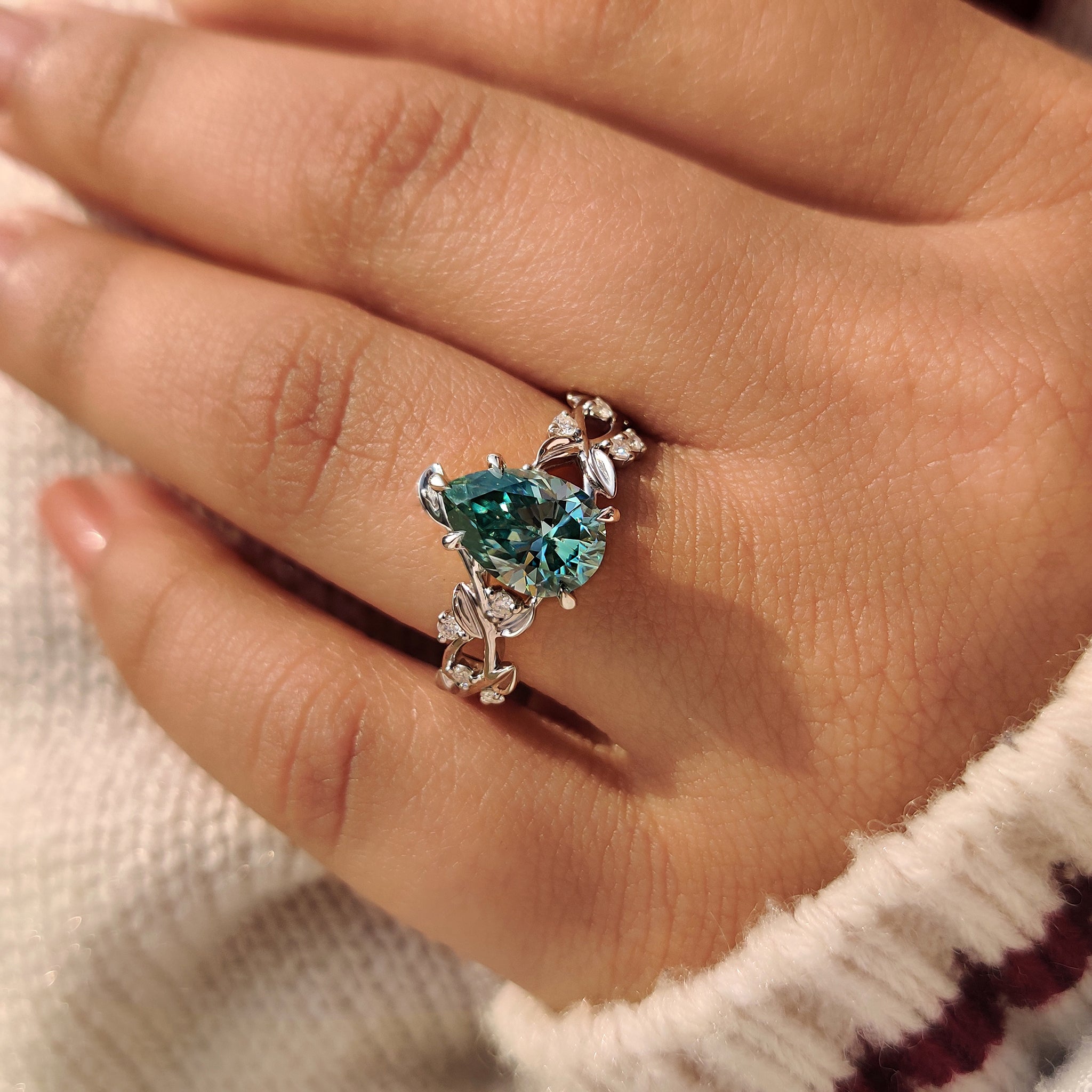 Cyan blue pear moissanite ring with floral five claw