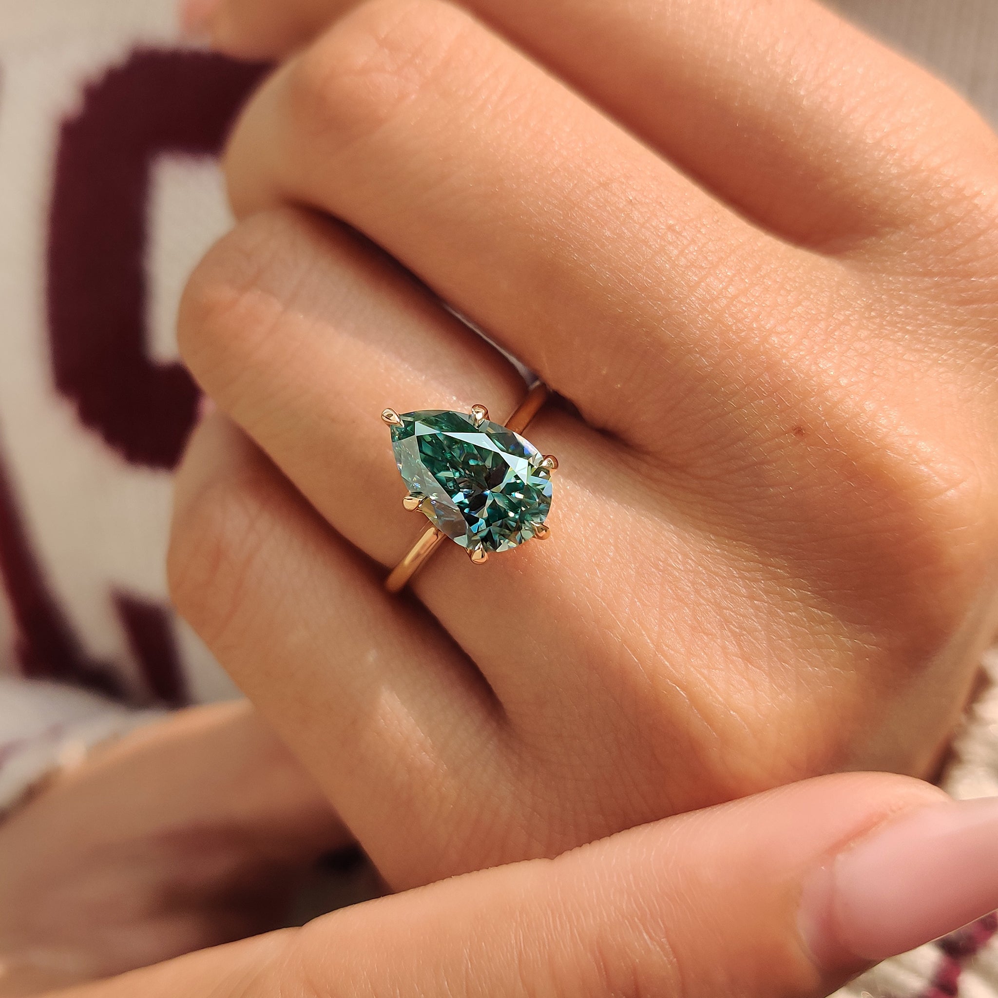 Cyan blue pear moissanite ring six claw prong.
