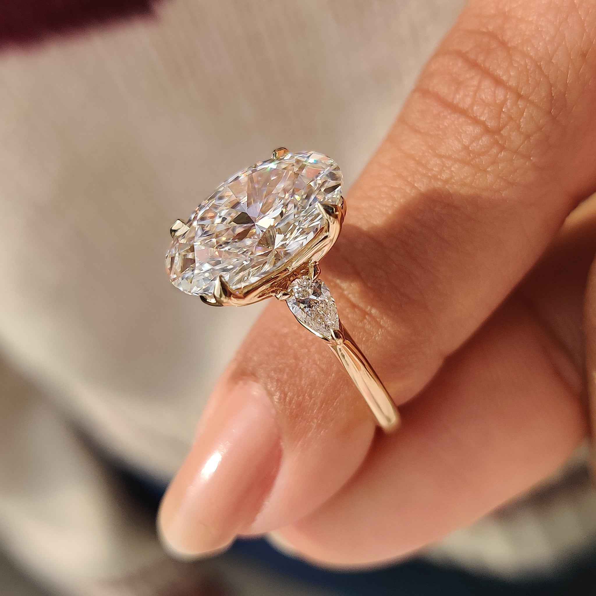 Oval center diamond ring with four claw prong setting
