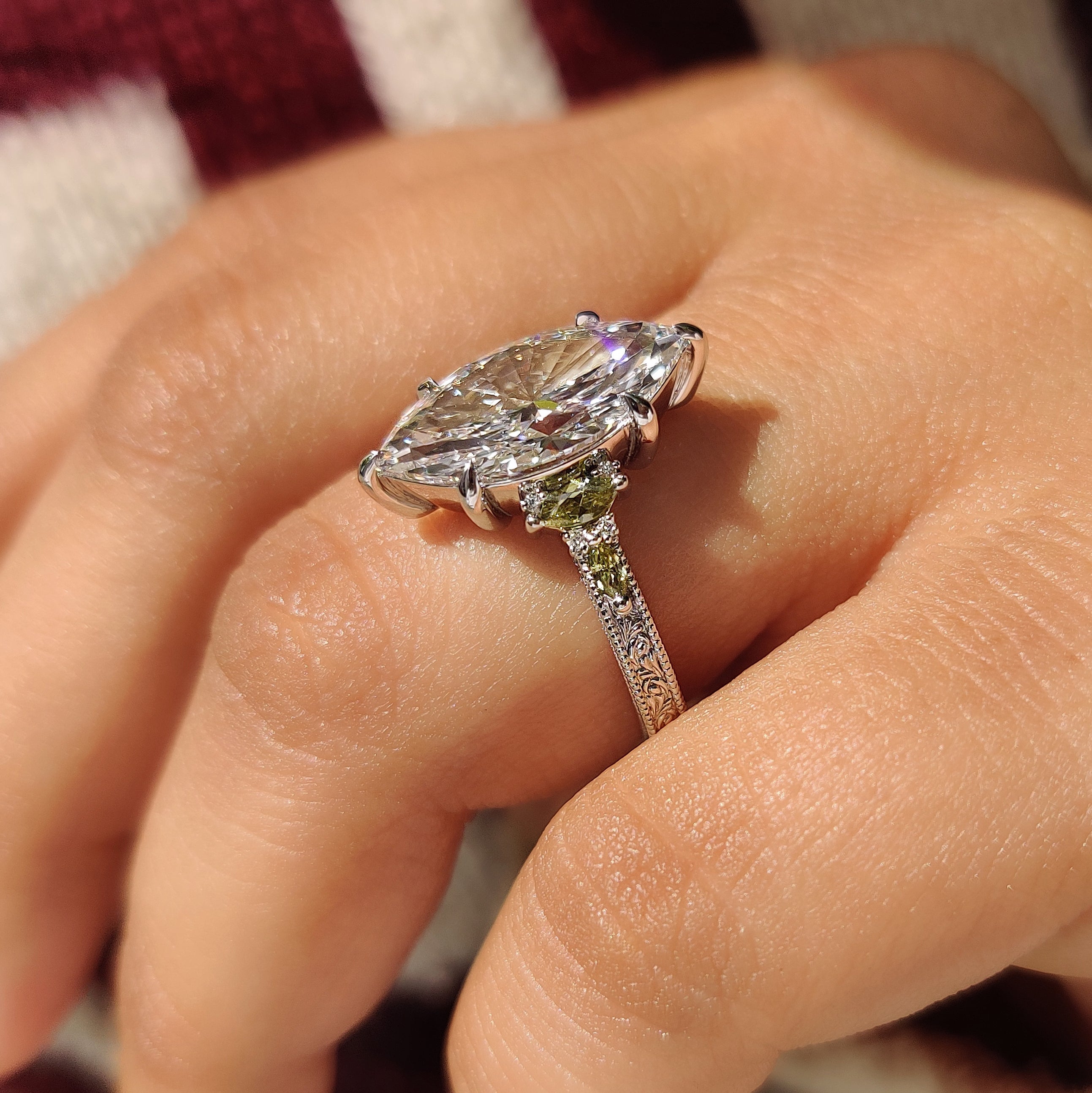 Handmade marquise engagement ring with round side stone accents

