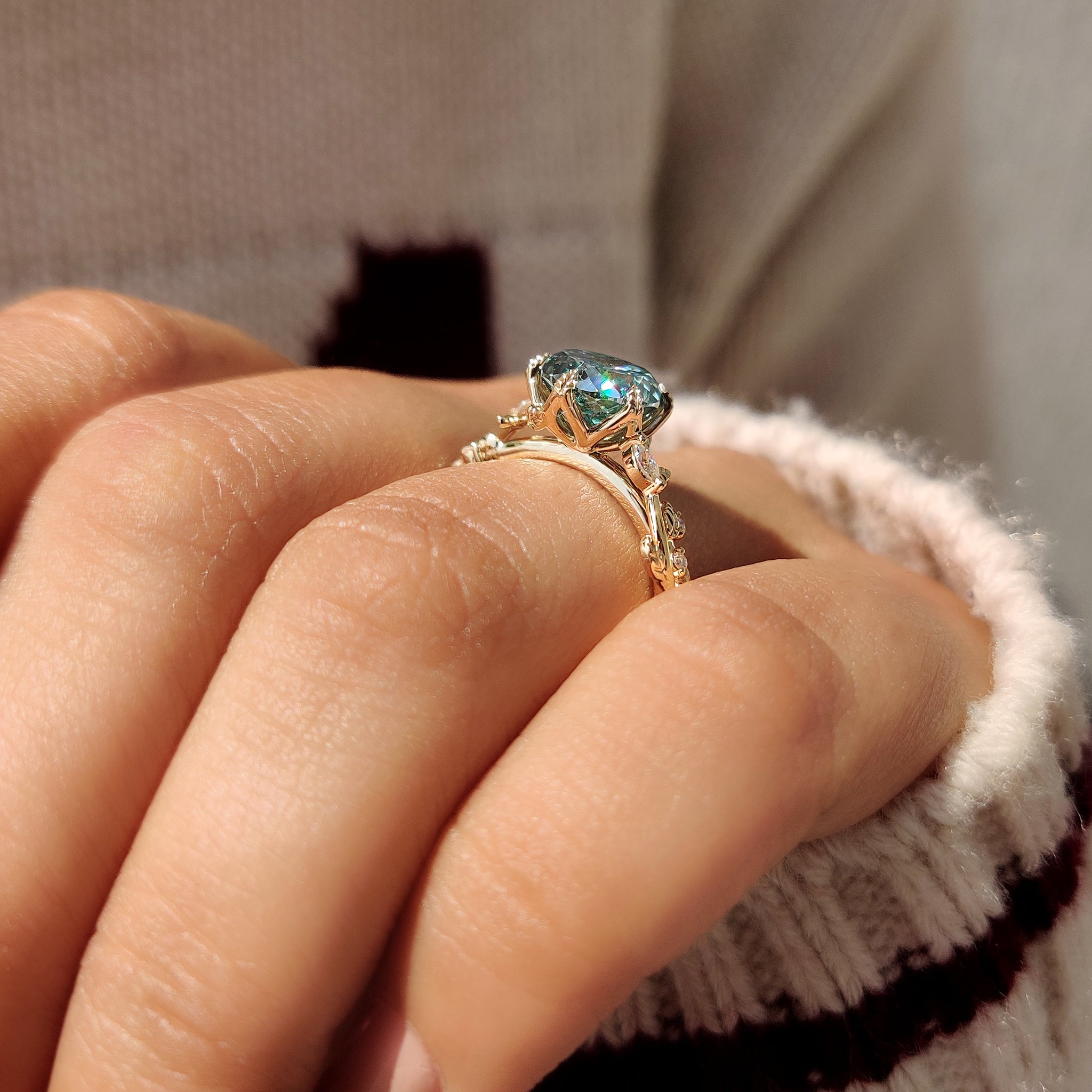 Cyan blue moissanite ring with six leaf style prong setting.
