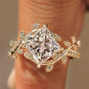 Princess cut engagement ring with leaf and vine bypass shank.
