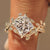 Princess cut engagement ring with leaf and vine bypass shank.
