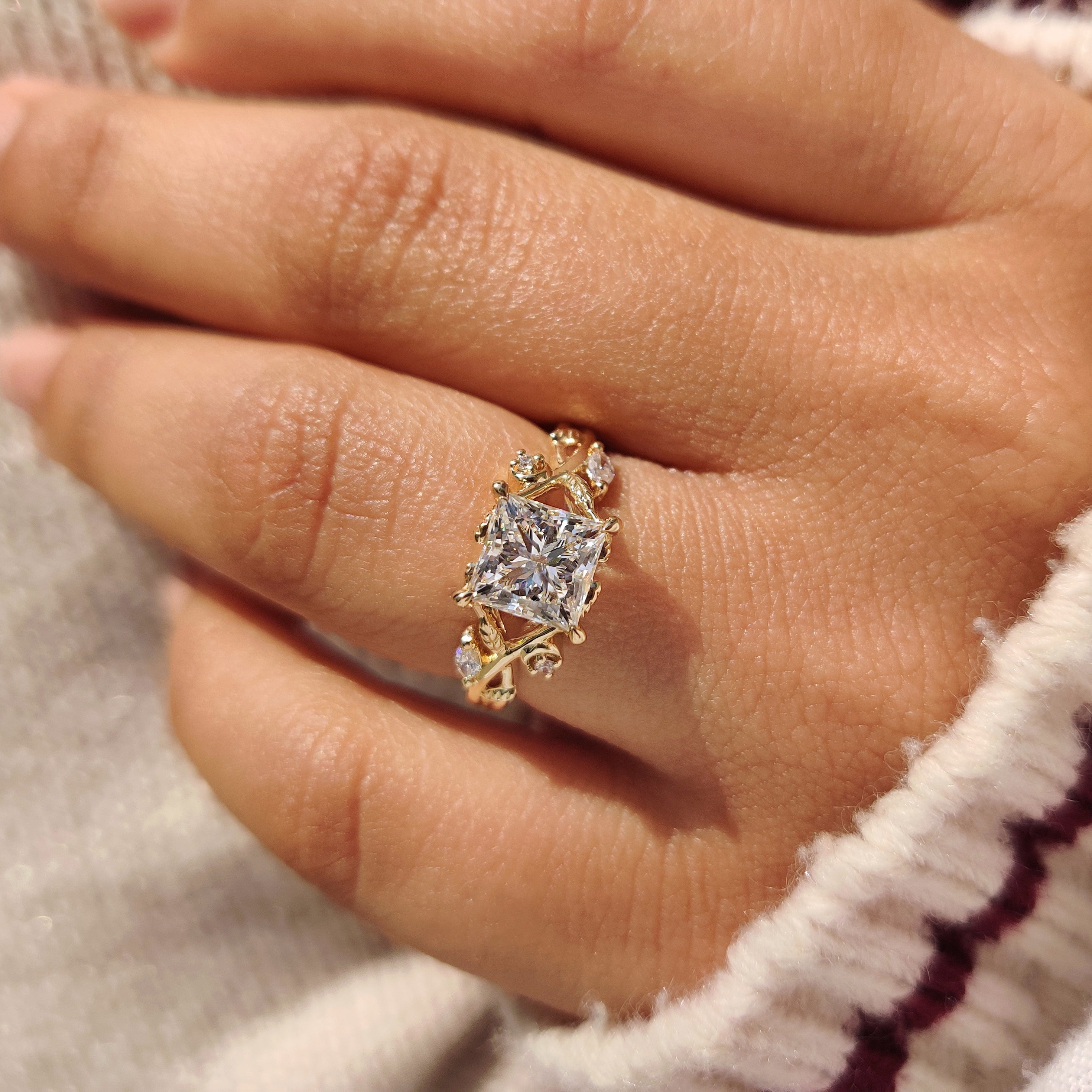 Princess diamond ring with leaf design and claw prong.
