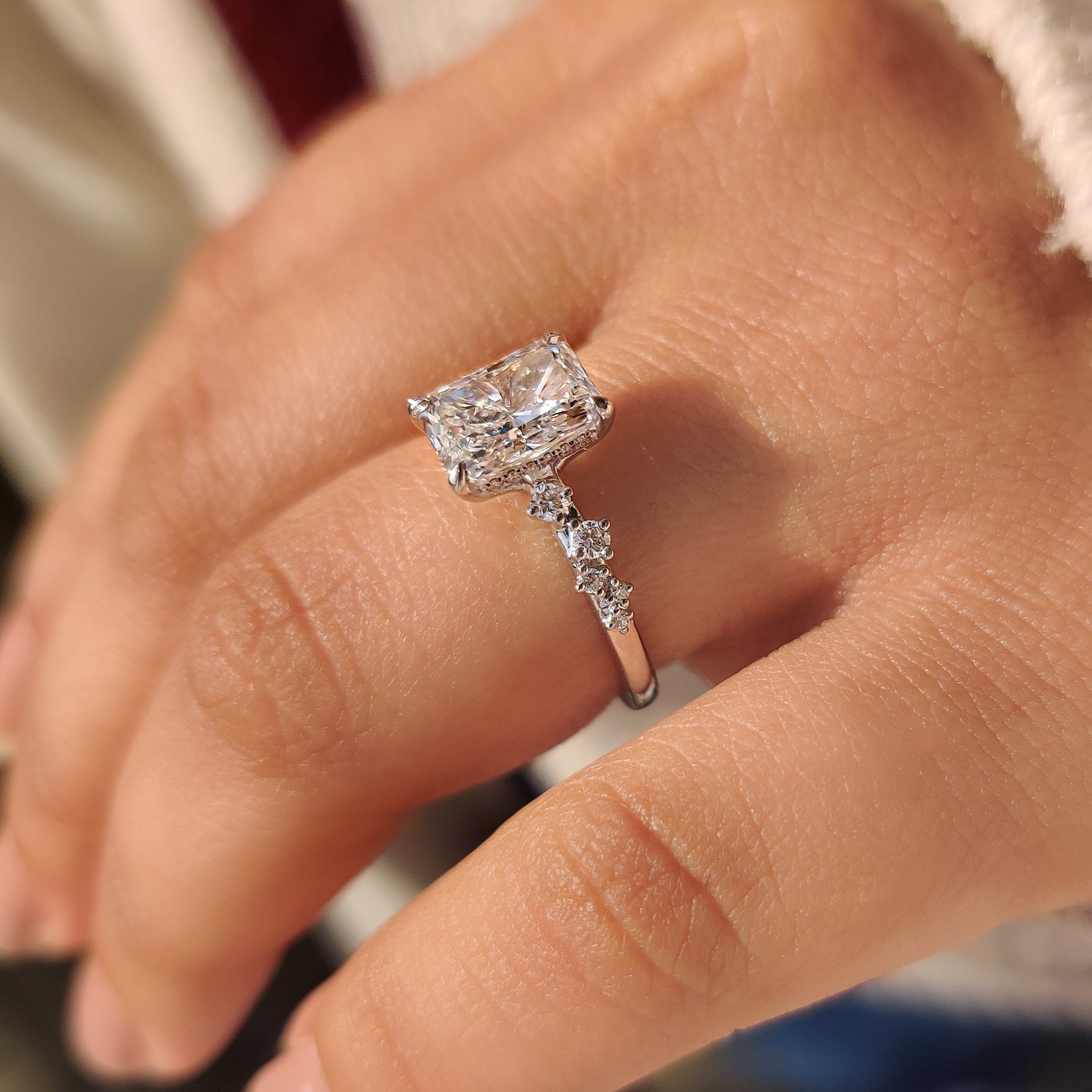 Radiant cut lab grown diamond ring with four claw prong setting.
