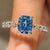Cushion cut blue diamond ring with pave band.

