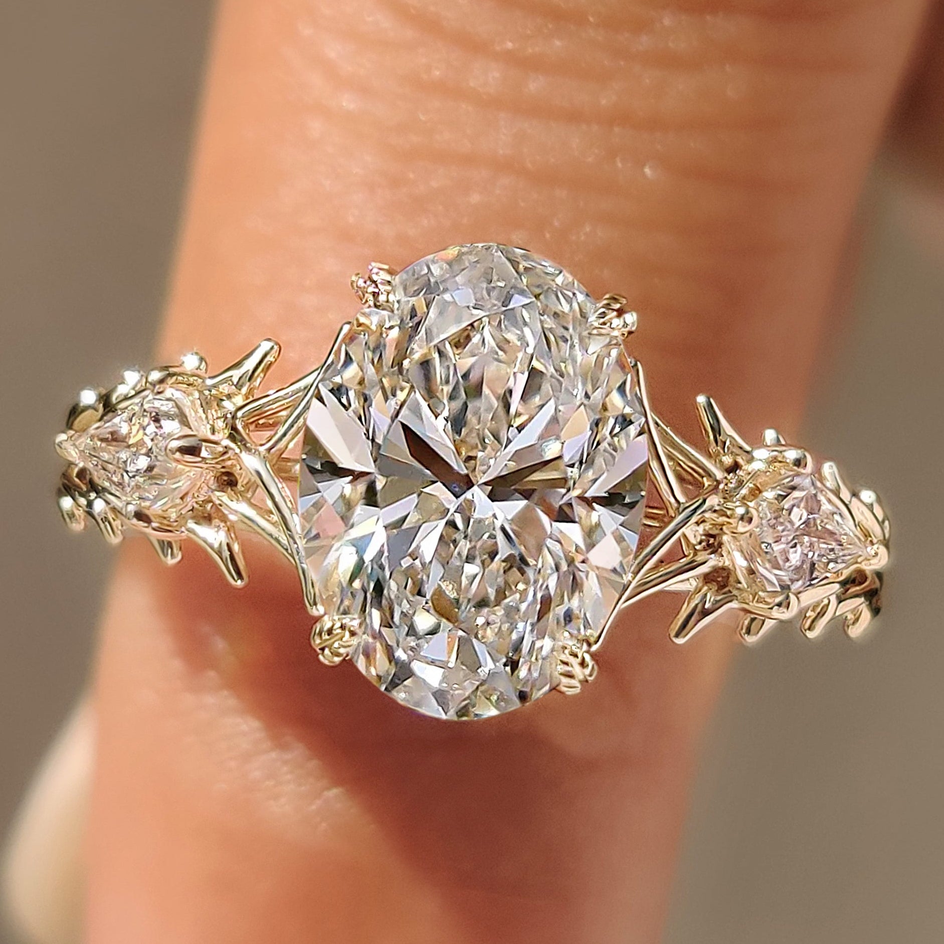 Oval three stone ring with kite side stones
