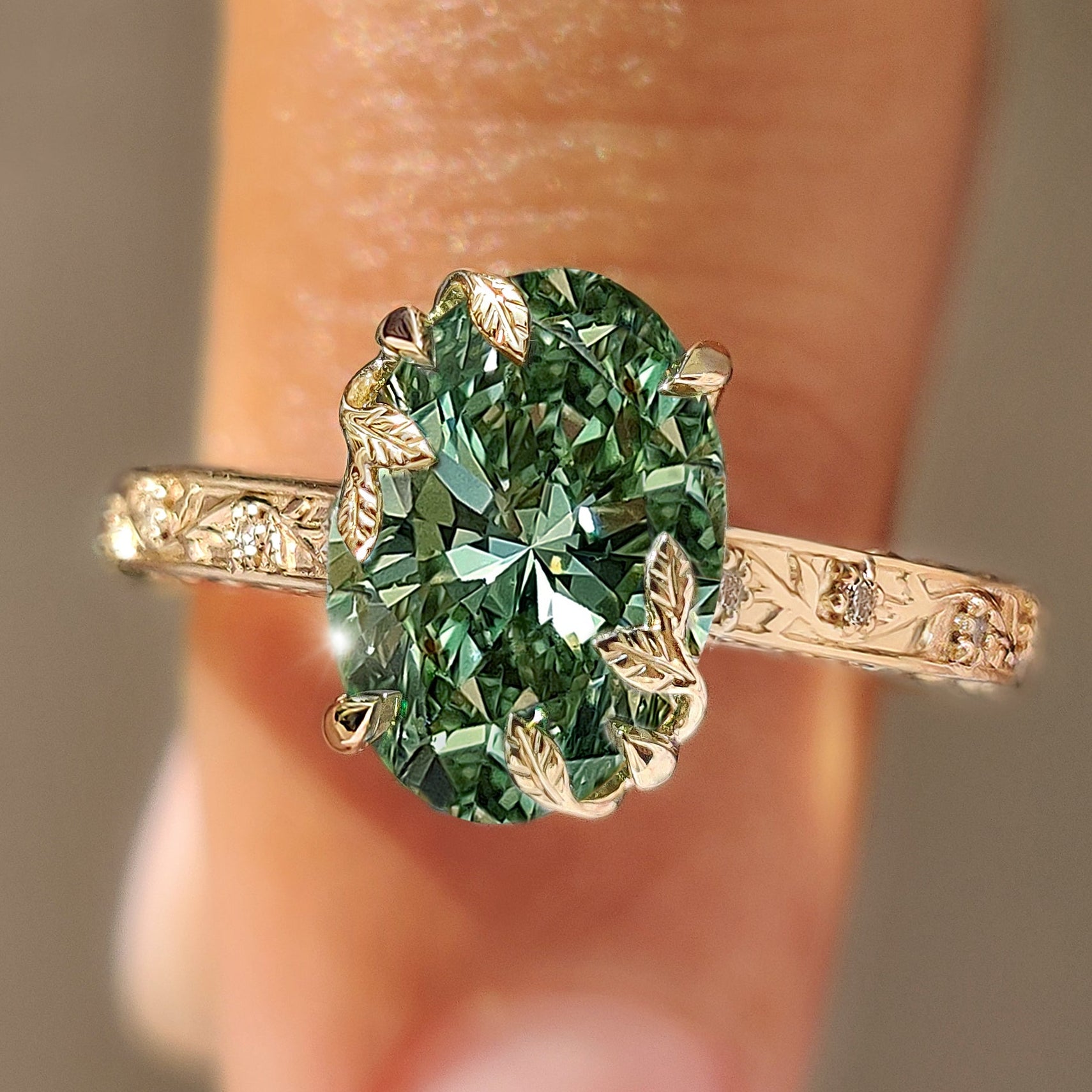 Green oval center diamond with round diamond accents.

