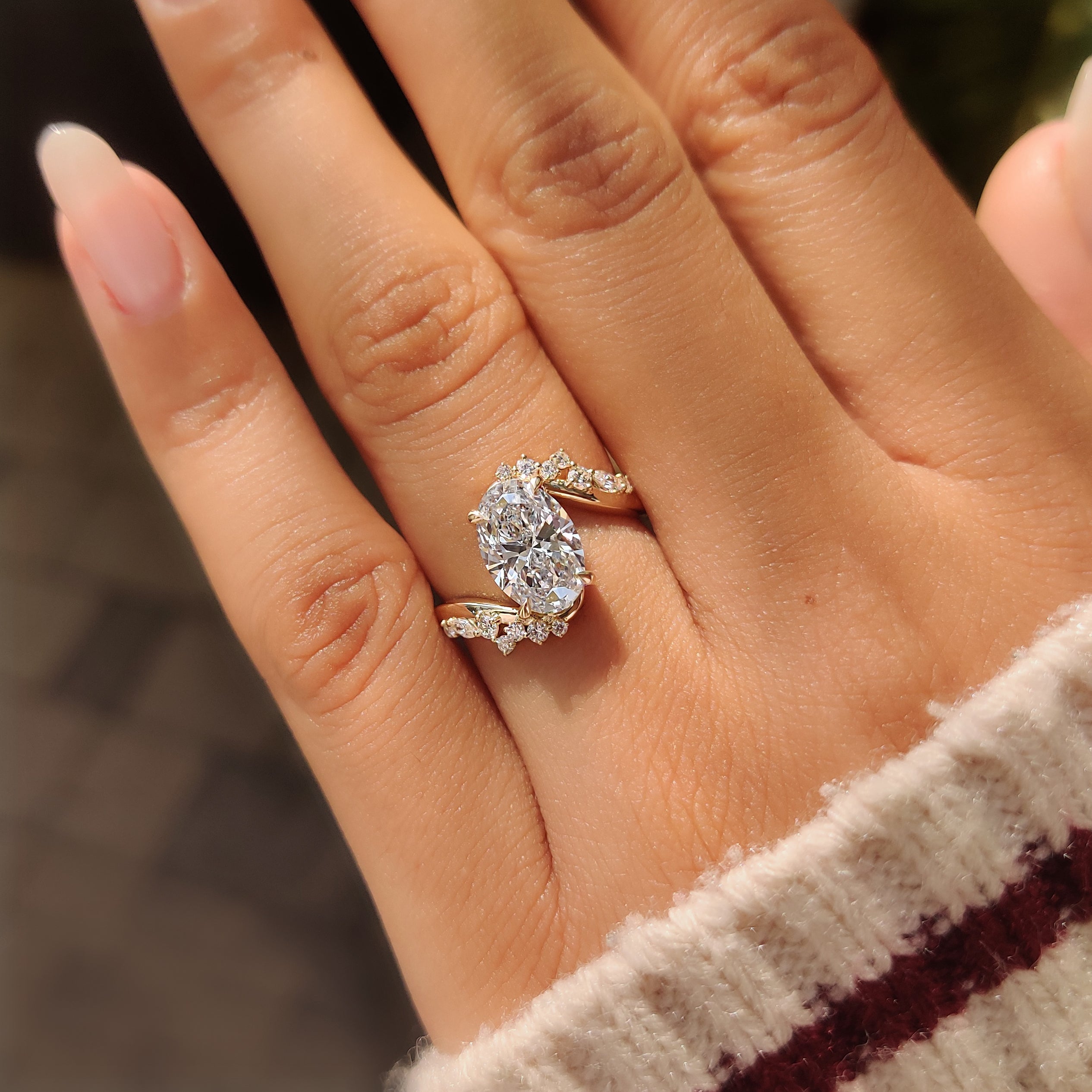 Lab grown oval diamond ring with marquise and round side stones.
