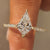 Kite cut engagement ring with round diamond pave band.
