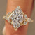 Marquise engagement ring with muse setting and cluster diamonds.
