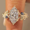 Marquise diamond bark texture split shank ring with round blue sapphire side stones.
