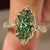 Green marquise diamond ring with marquise and round pave.
