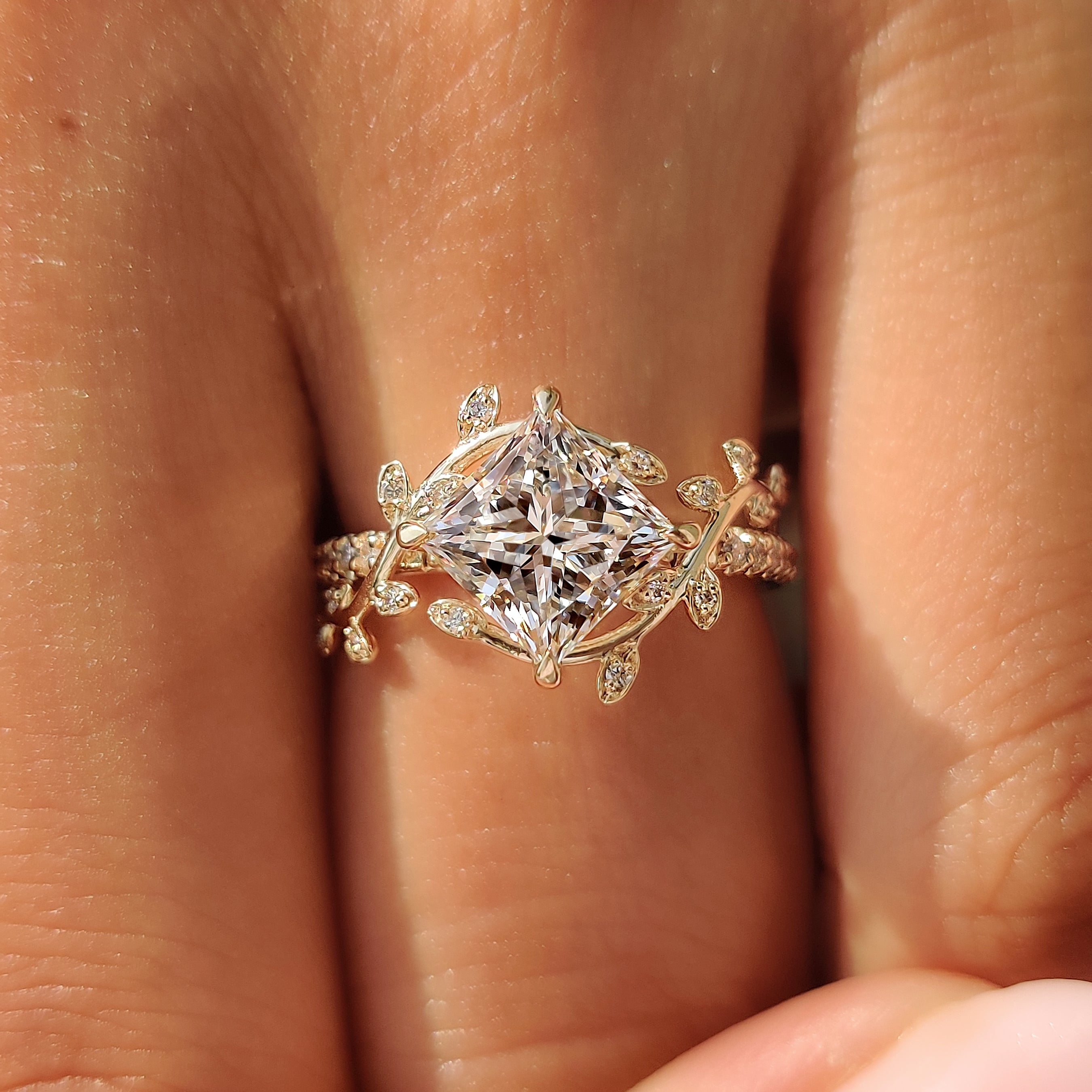 Yellow gold princess cut diamond ring with botanical details.

