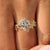 Yellow gold princess cut diamond ring with botanical details.

