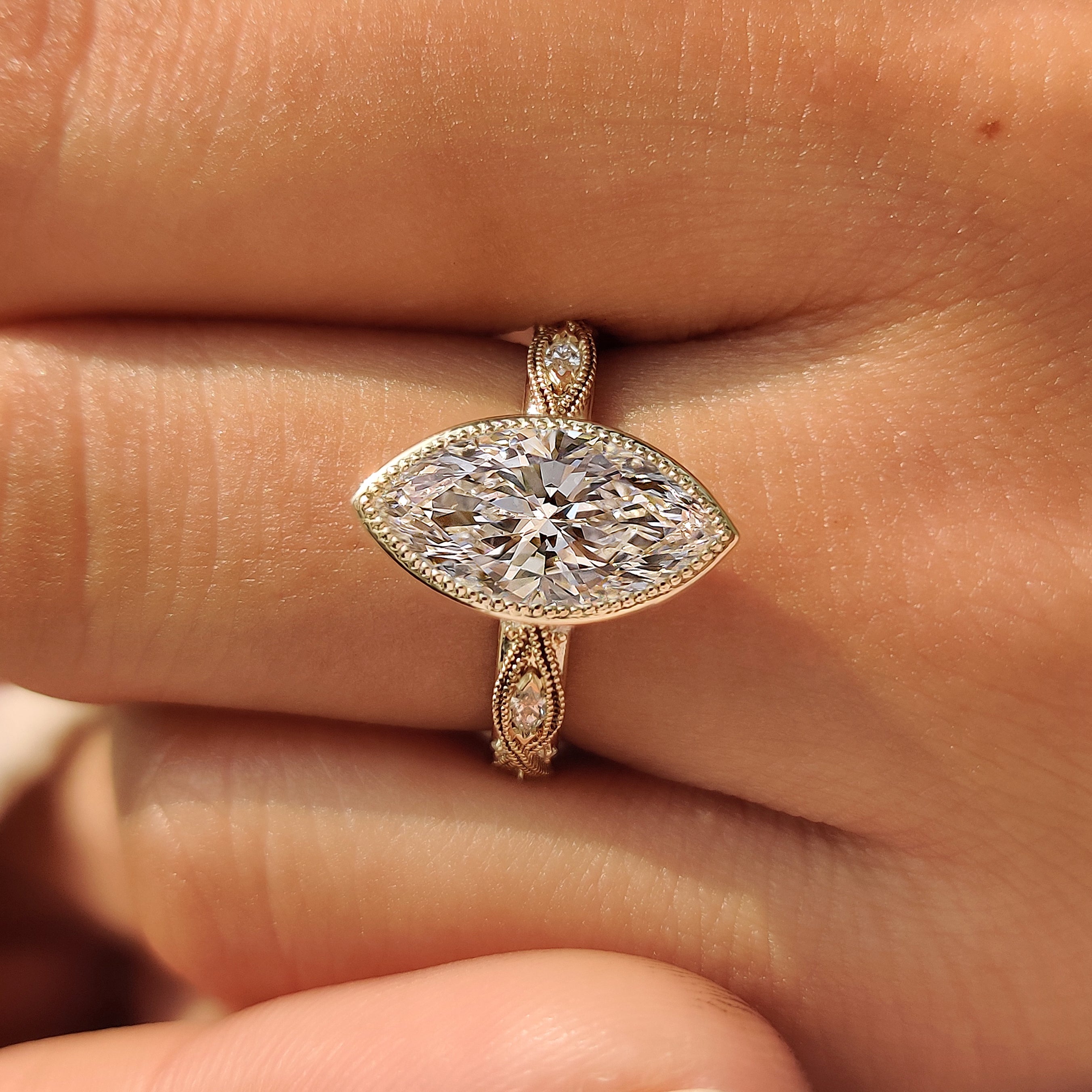 Marquise and round accent stones on a bezel set ring.
