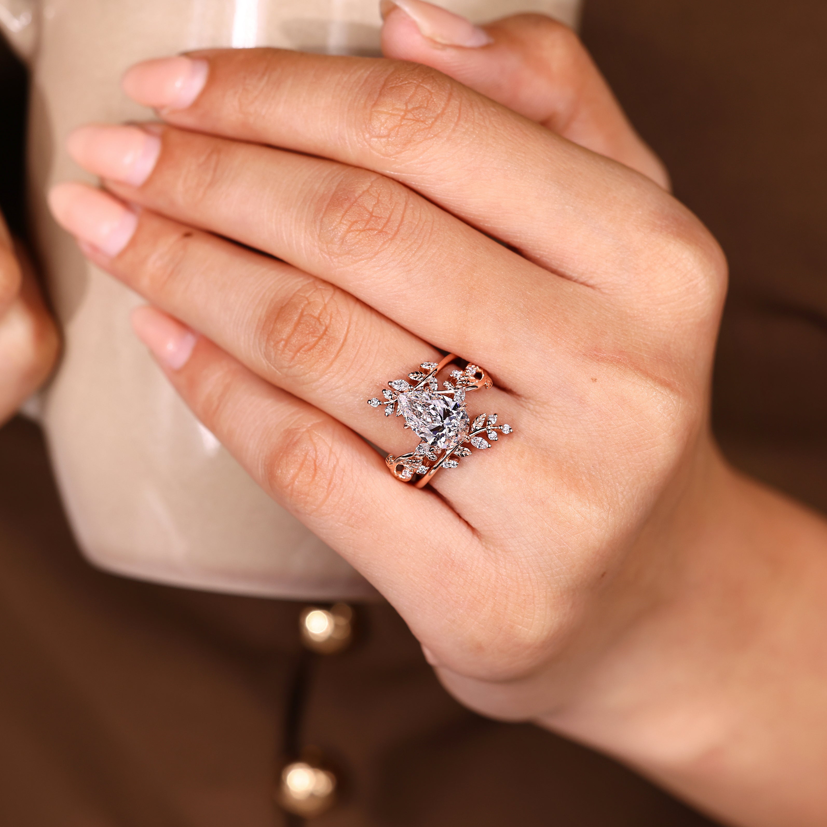 Pear shaped engagement ring with nature inspired guard band
