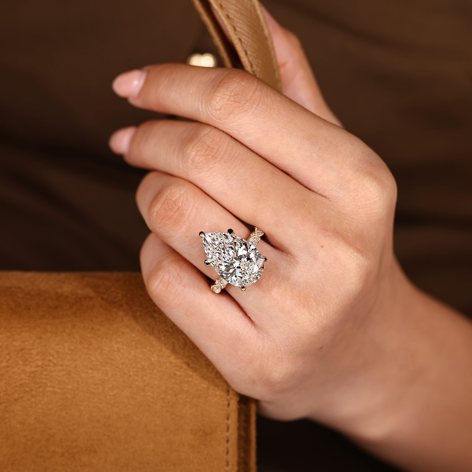 Pear cut center diamond secured by five claw prong setting
