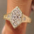Dutch marquise three stone ring with round diamond side stones.
