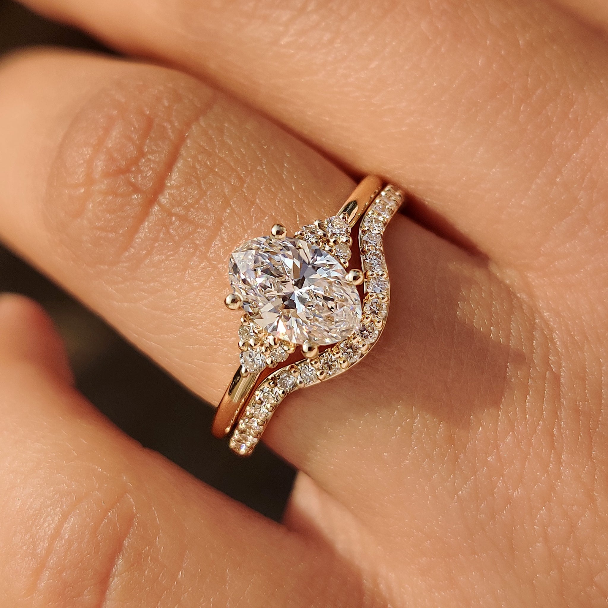 Oval engagement ring with seven stone curved wedding band.
