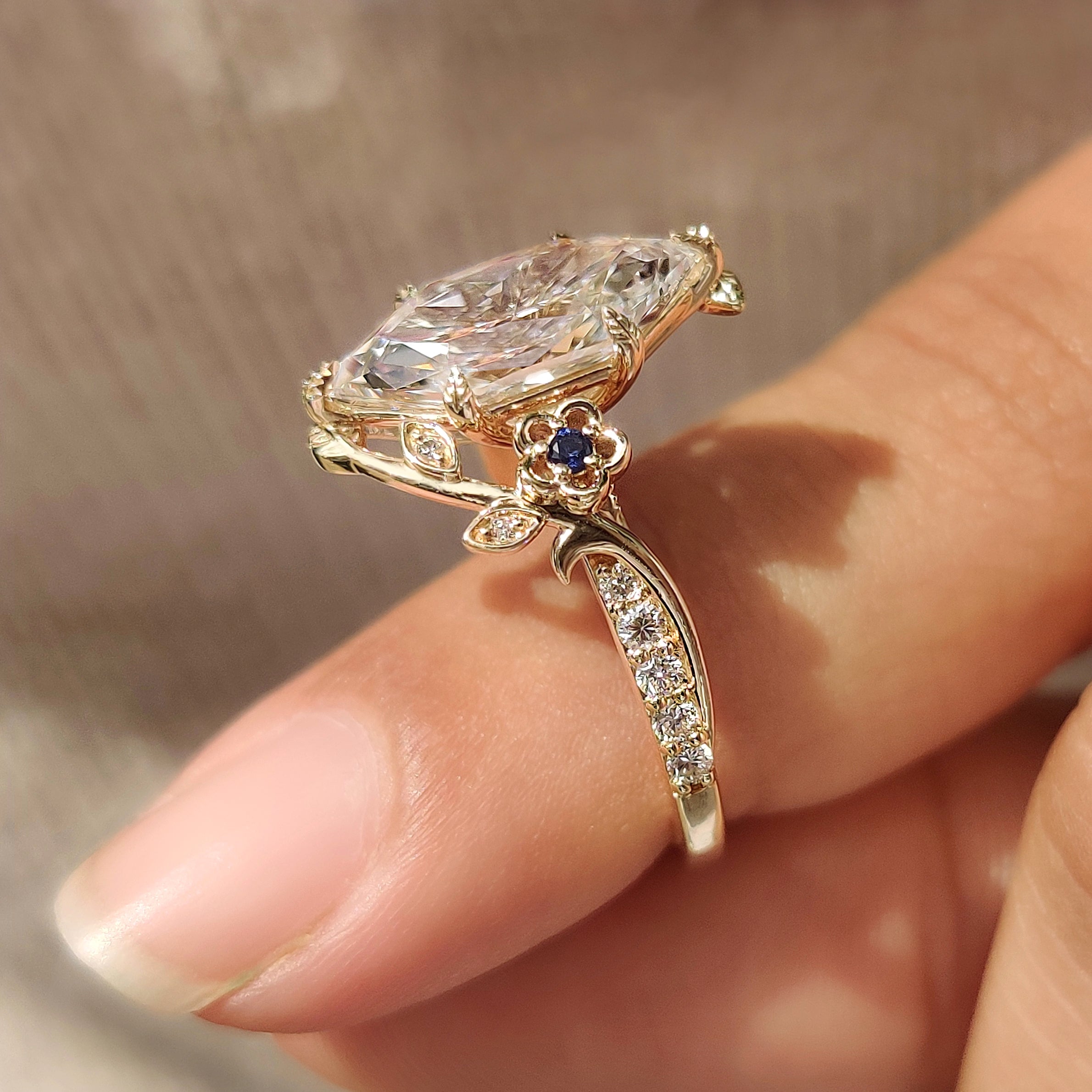Blue sapphire side stones with leaf style prong setting
