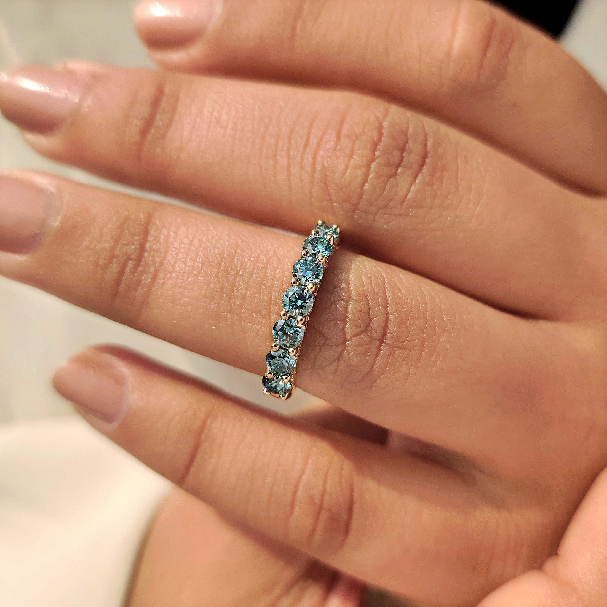 Seven stone moissanite band with u prong pave style.
