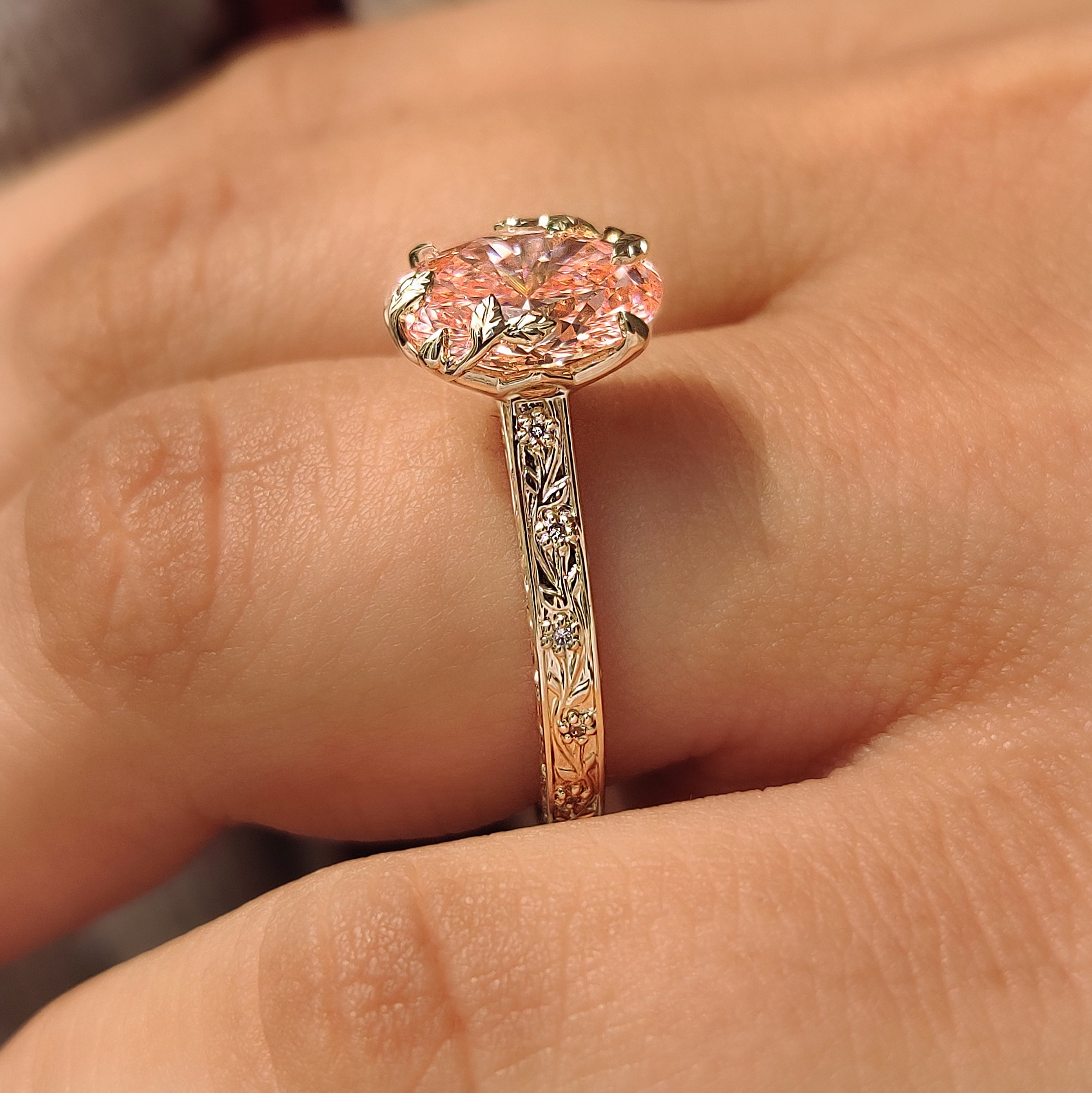 Four claw prongs pink oval cut diamond ring.
