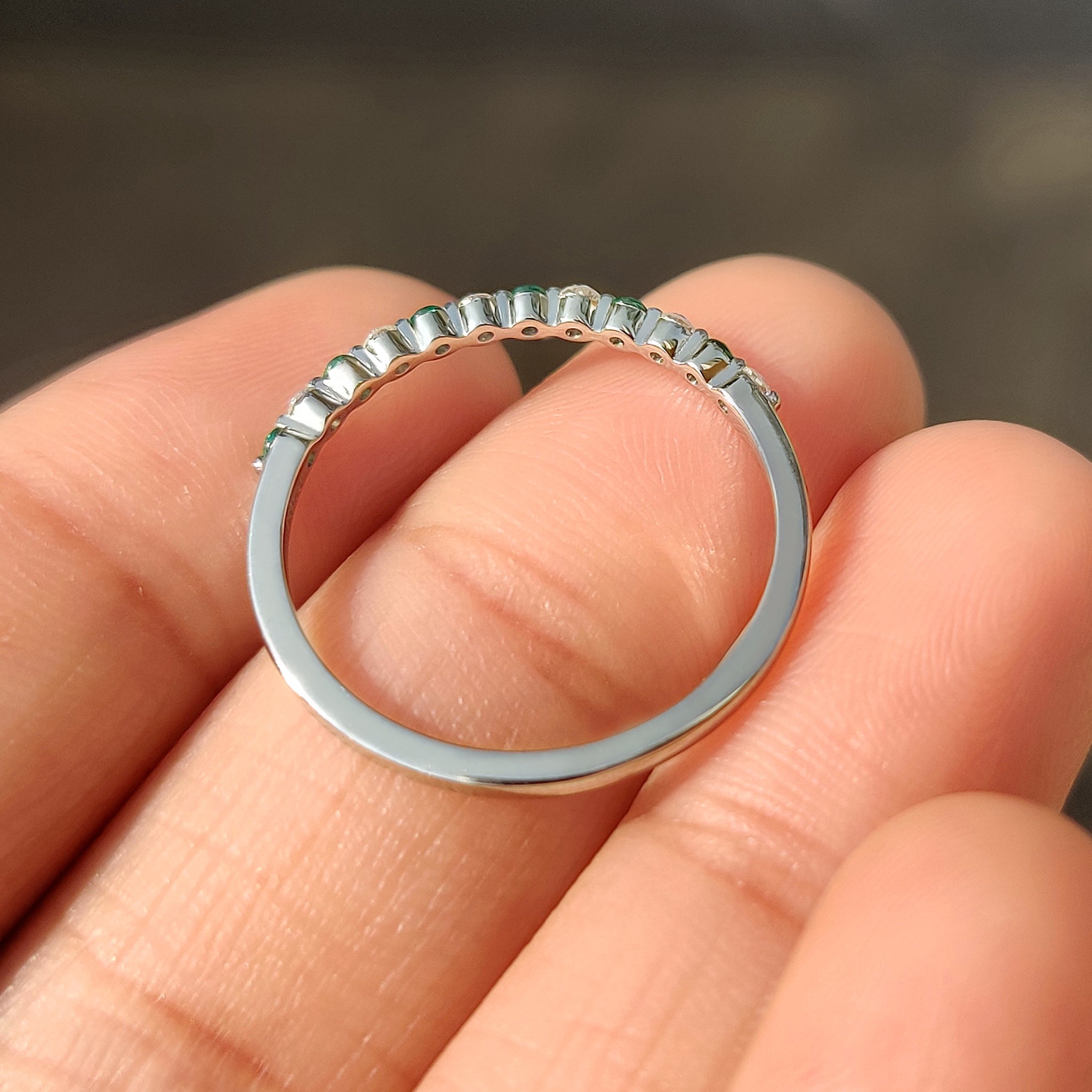 Handmade diamond and emerald half eternity band design.
