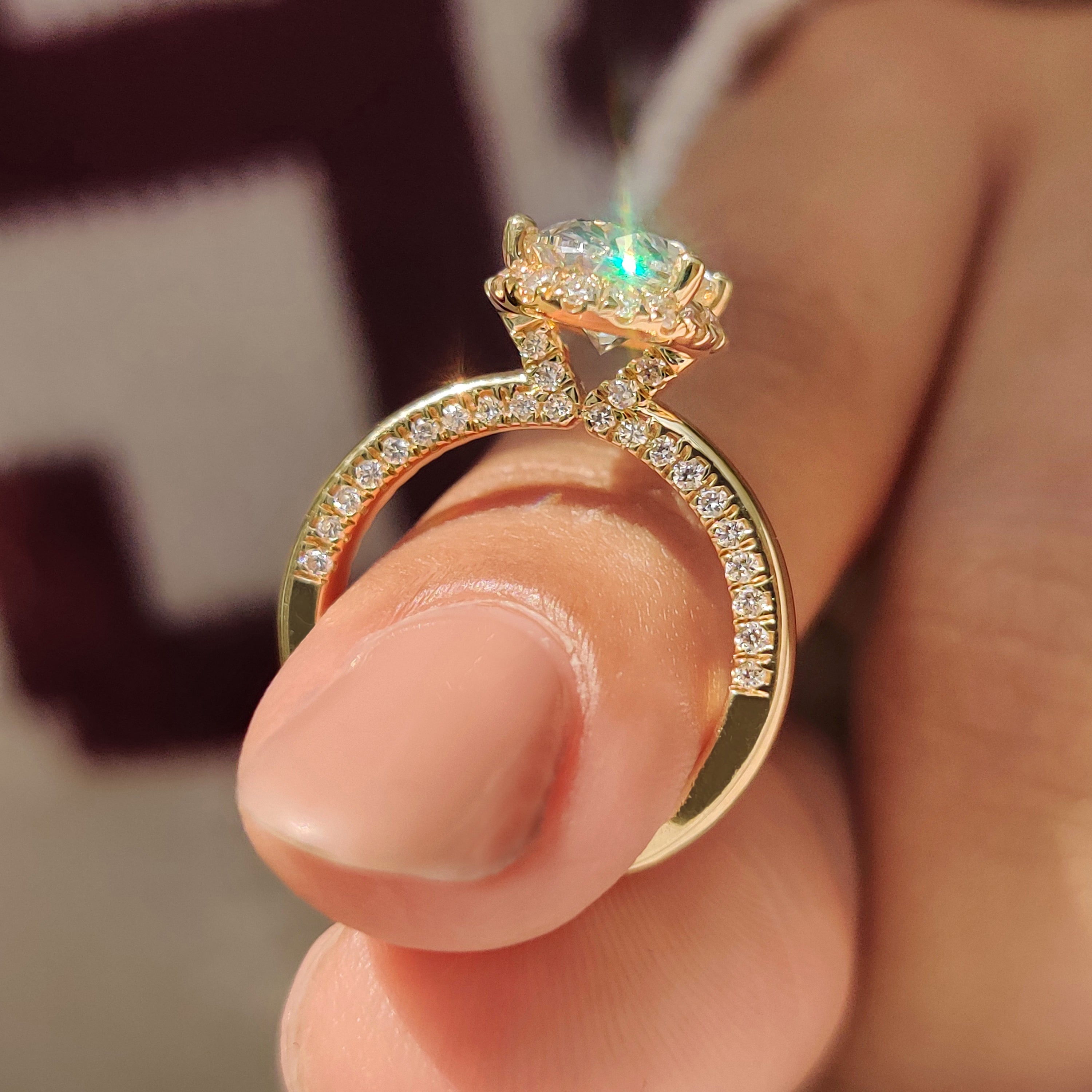 Basket setting holds oval cut diamond ring with halo detail.
