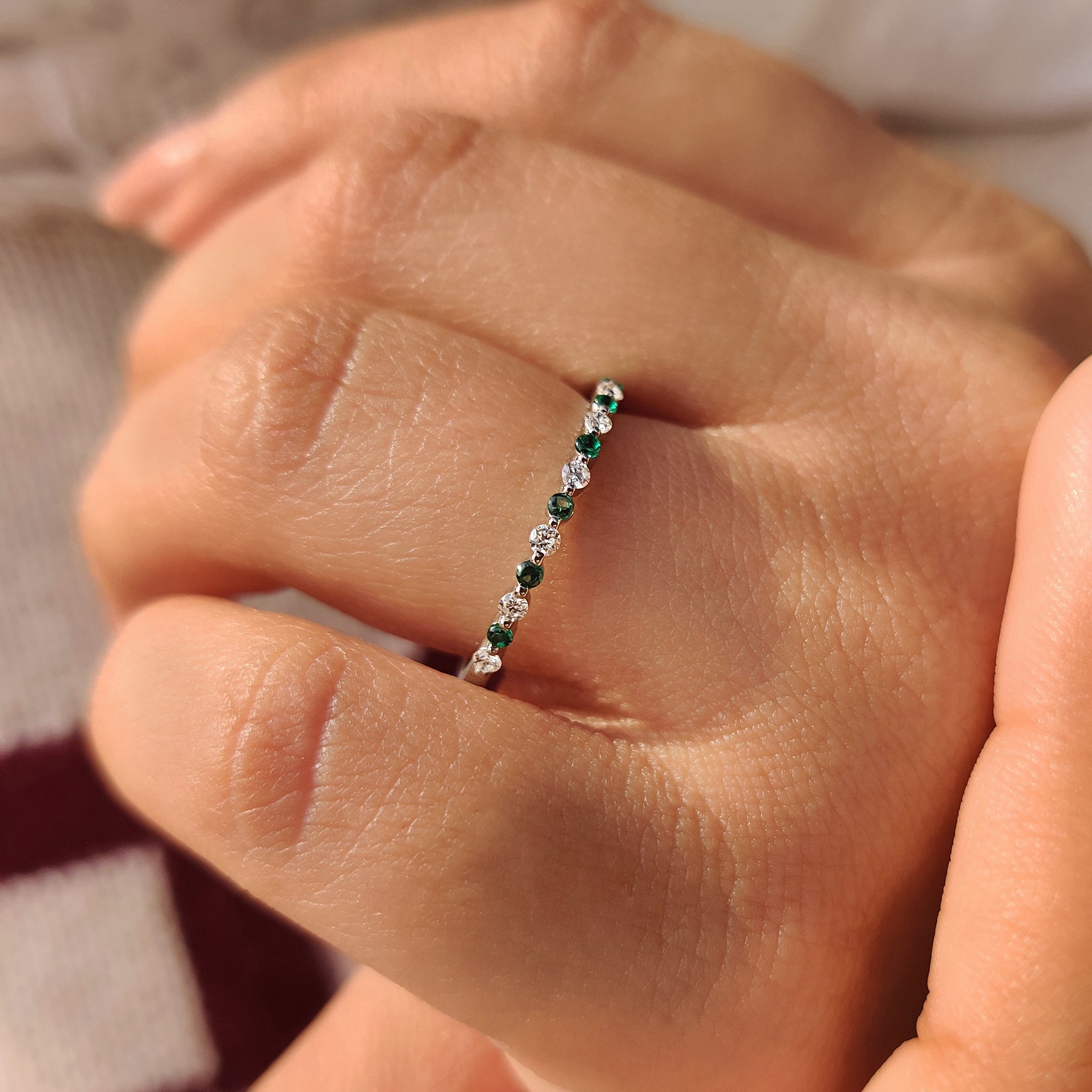 Lab grown diamond half eternity band with emerald accents.

