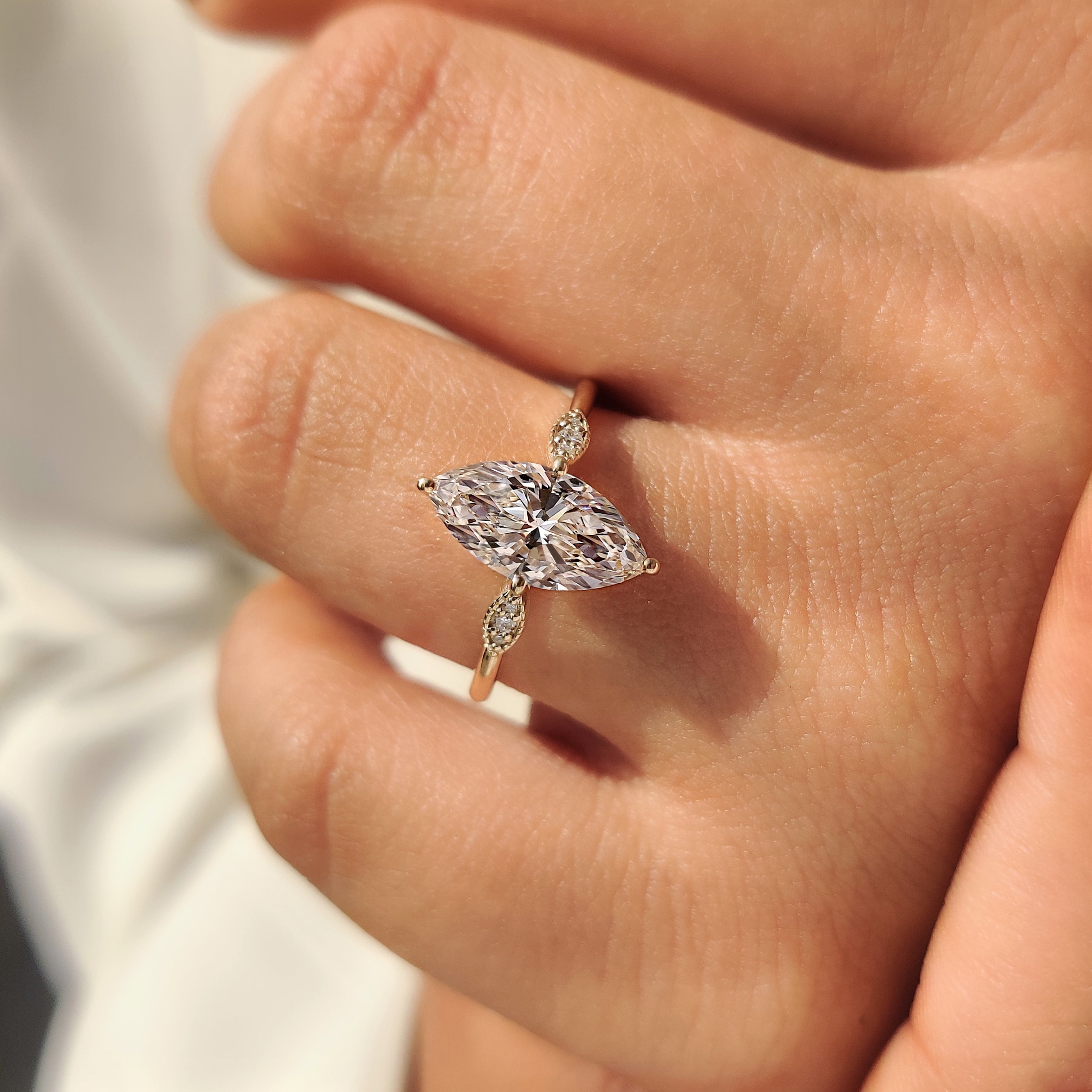 Compass prong marquise ring with round side stones.
