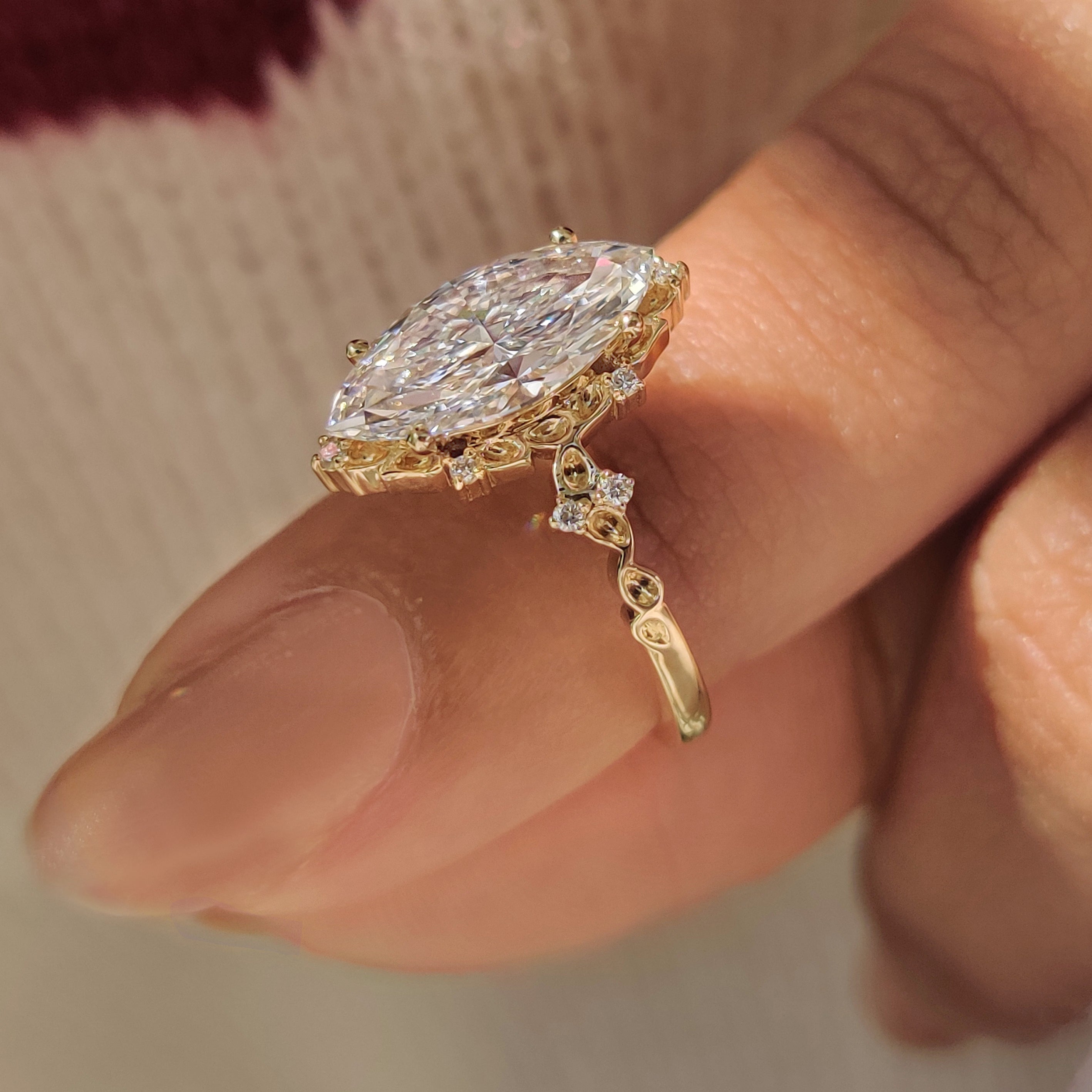 Marquise diamond ring with cluster setting and round stones.
