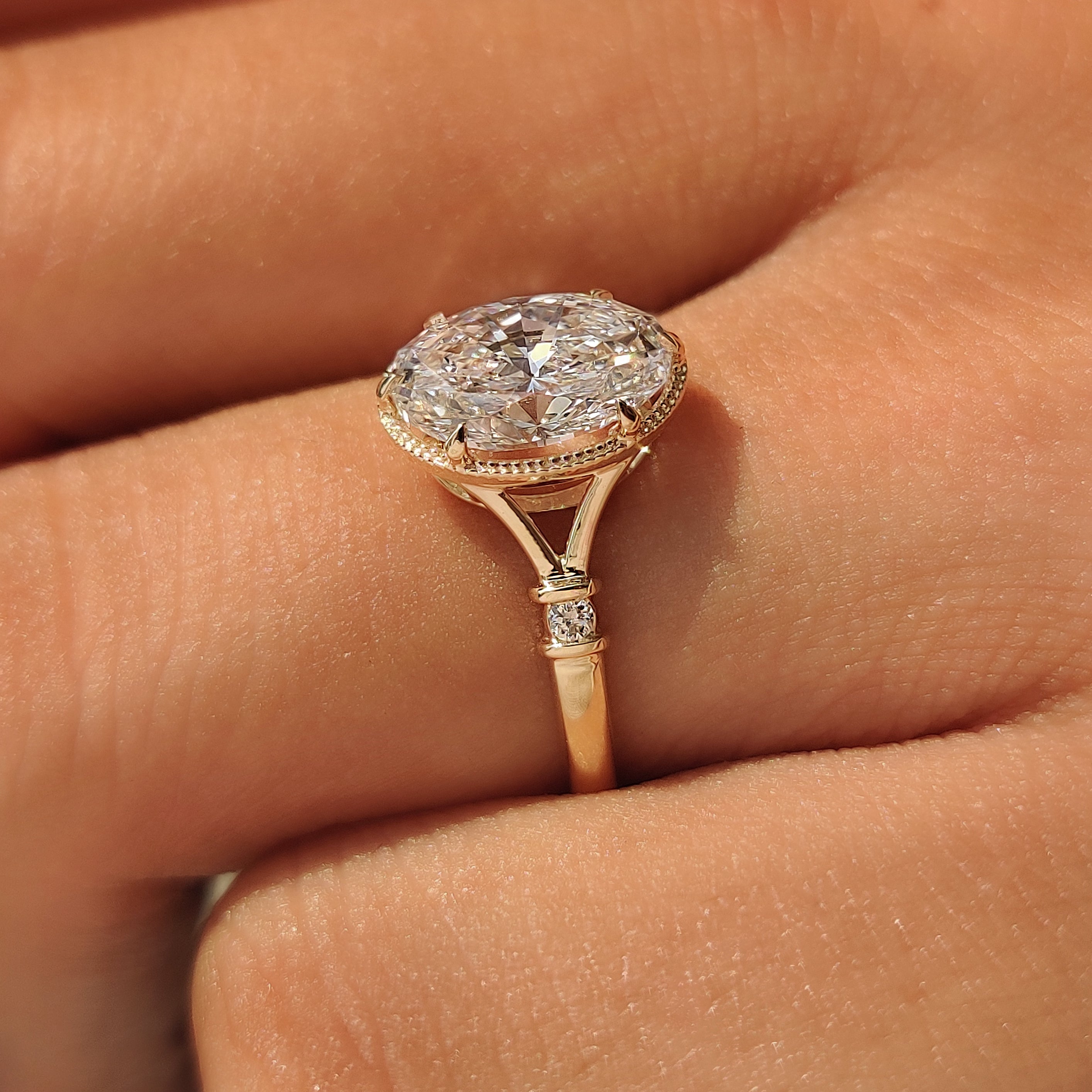 Oval lab grown diamond ring with round side stones.
