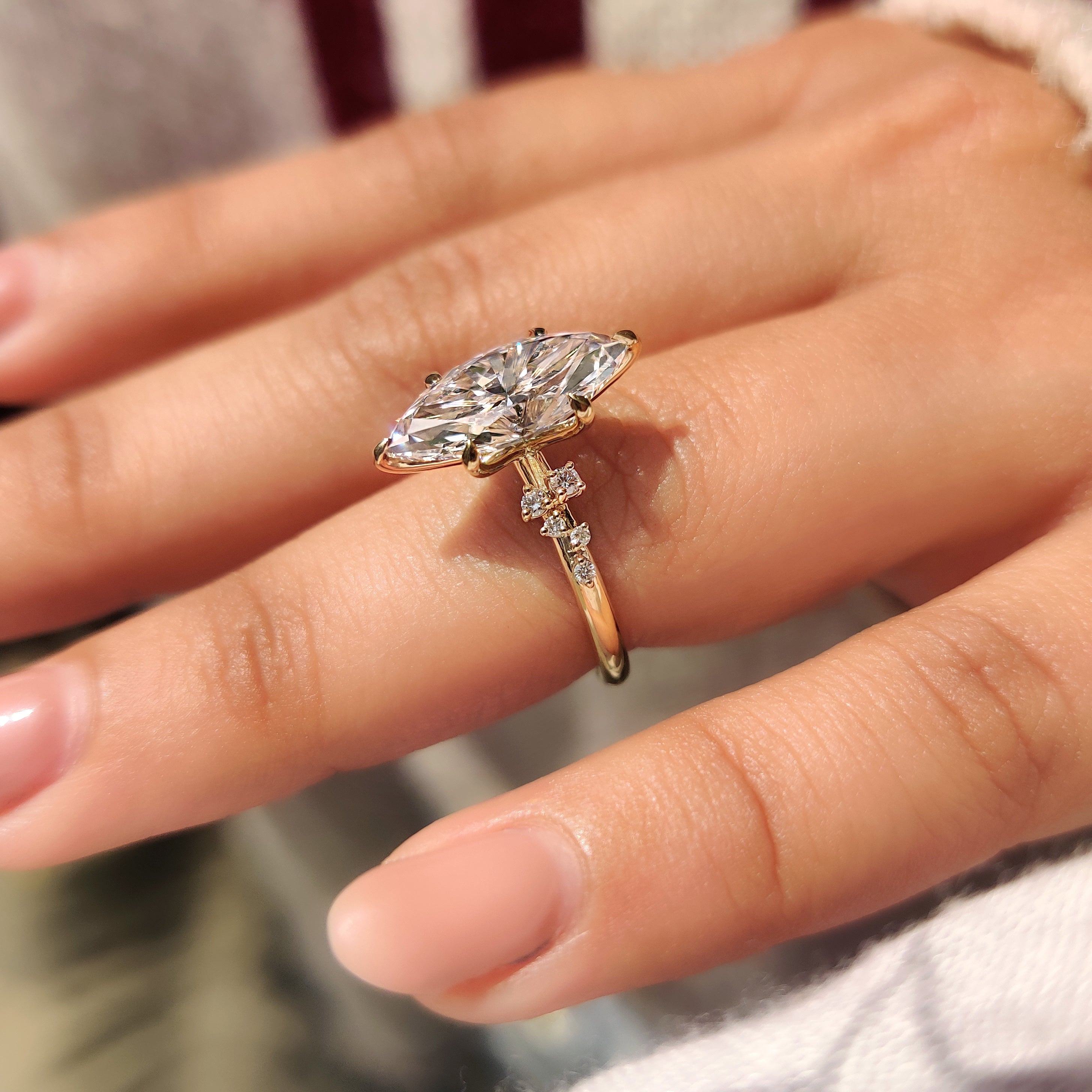 Marquise cut engagement ring shines through cluster setting and six claws.
