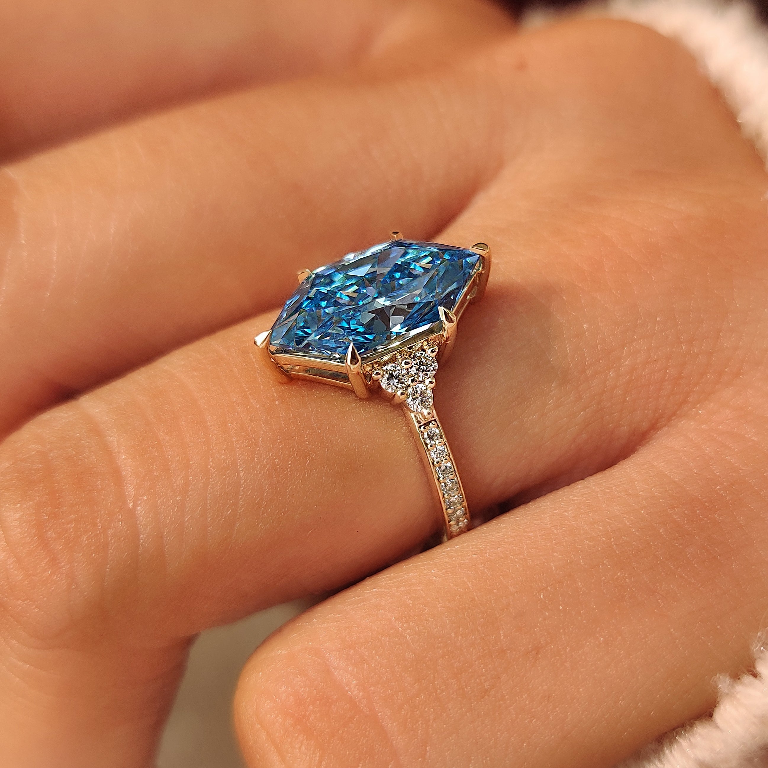 Muse setting with round diamonds around the center stone.

