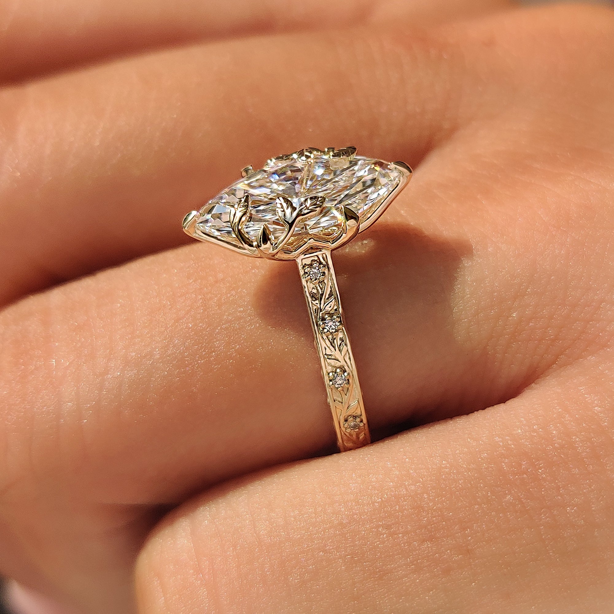 Lab grown marquise diamond engagement ring with round accents.
