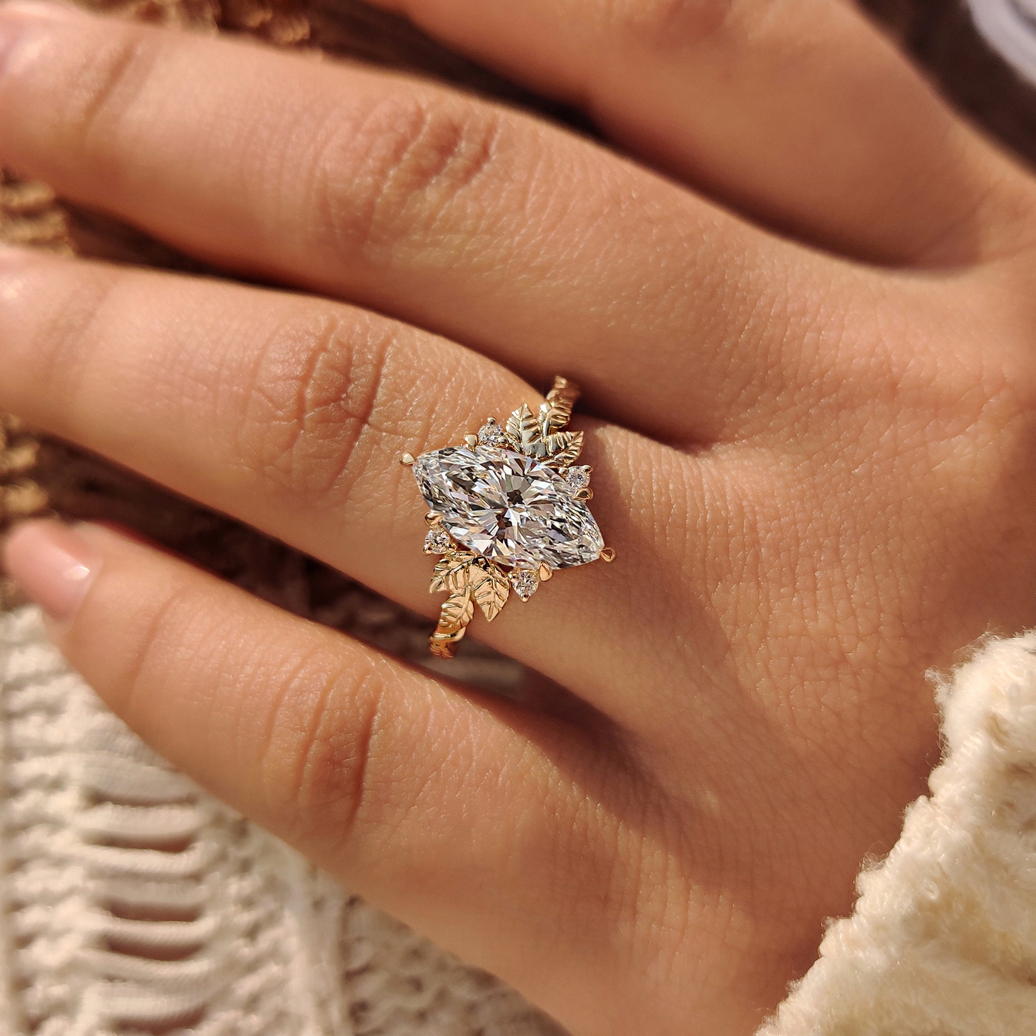 
Marquise diamond engagement ring with leaf detail and side stones.