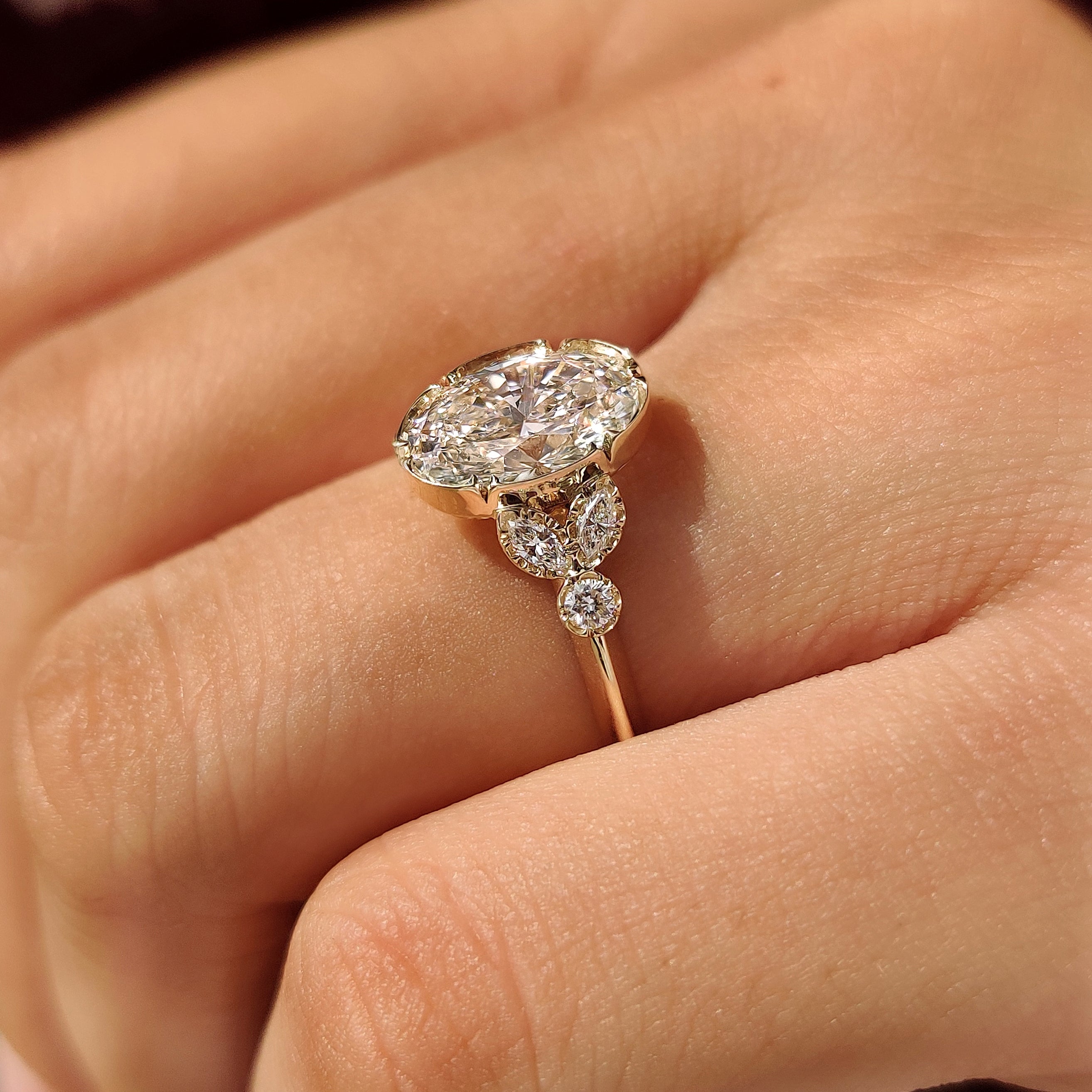 Marquise and round side stones on oval ring
