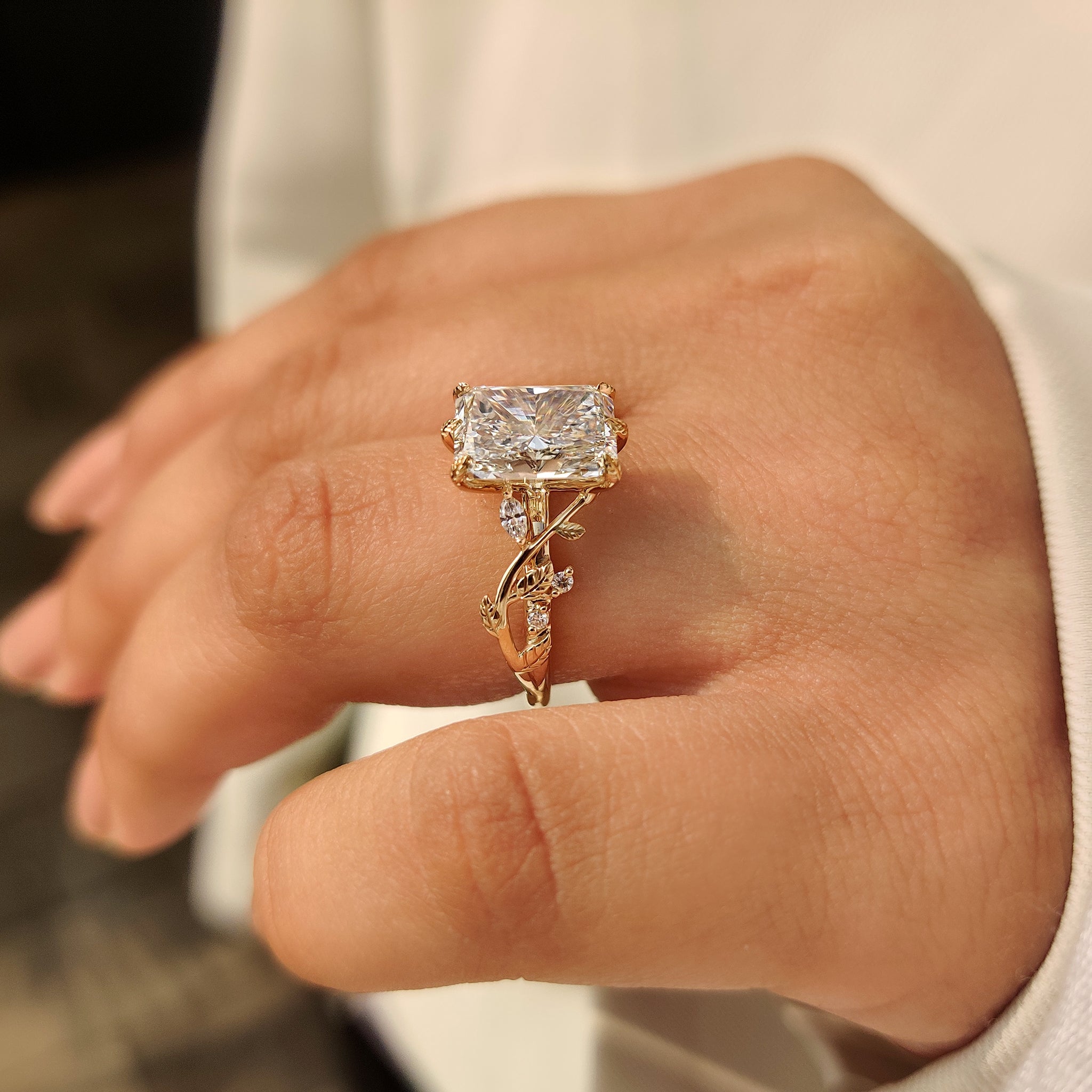 Nature inspired engagement ring with round and marquise side stone accents
