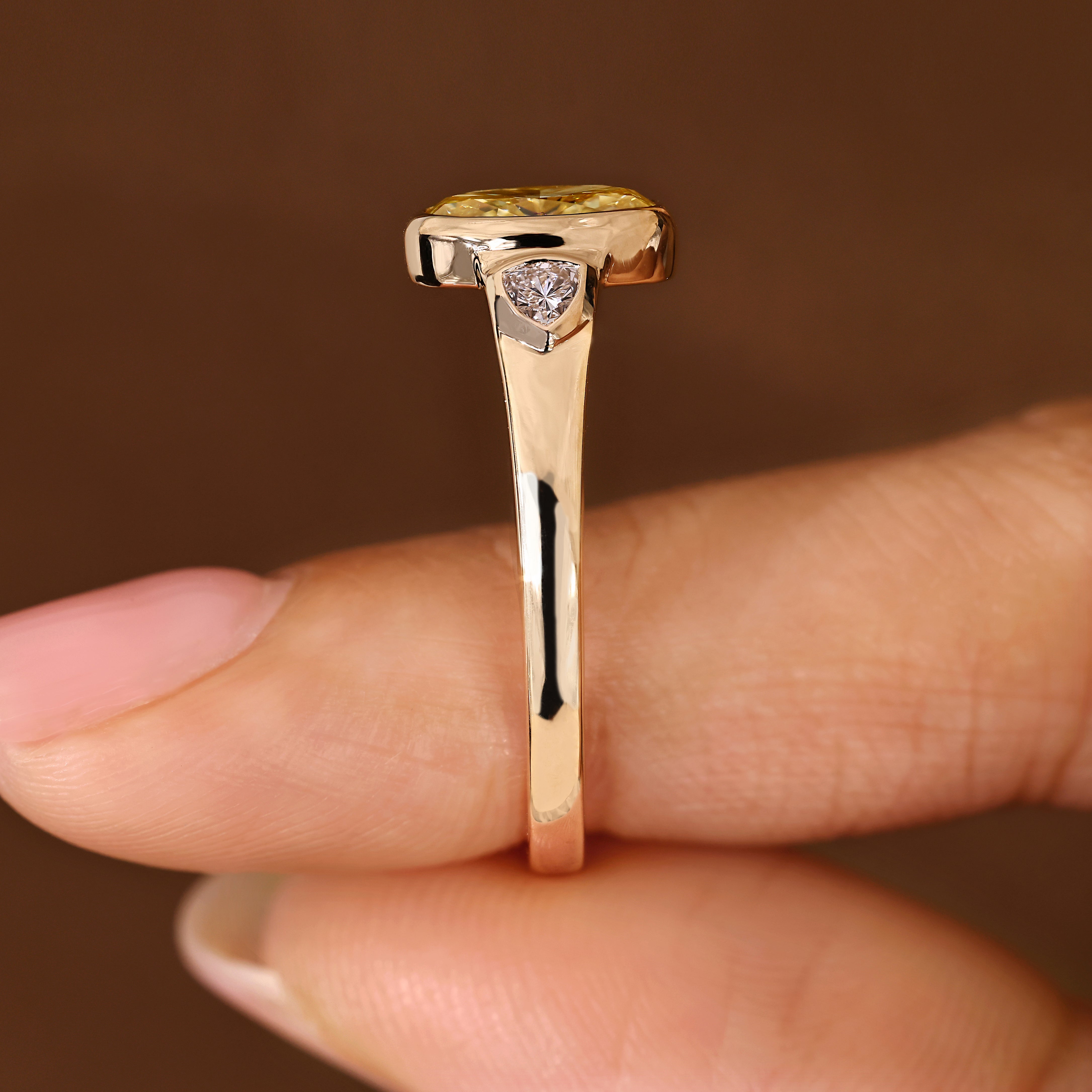 Light yellow oval diamond ring with trillion side stones
