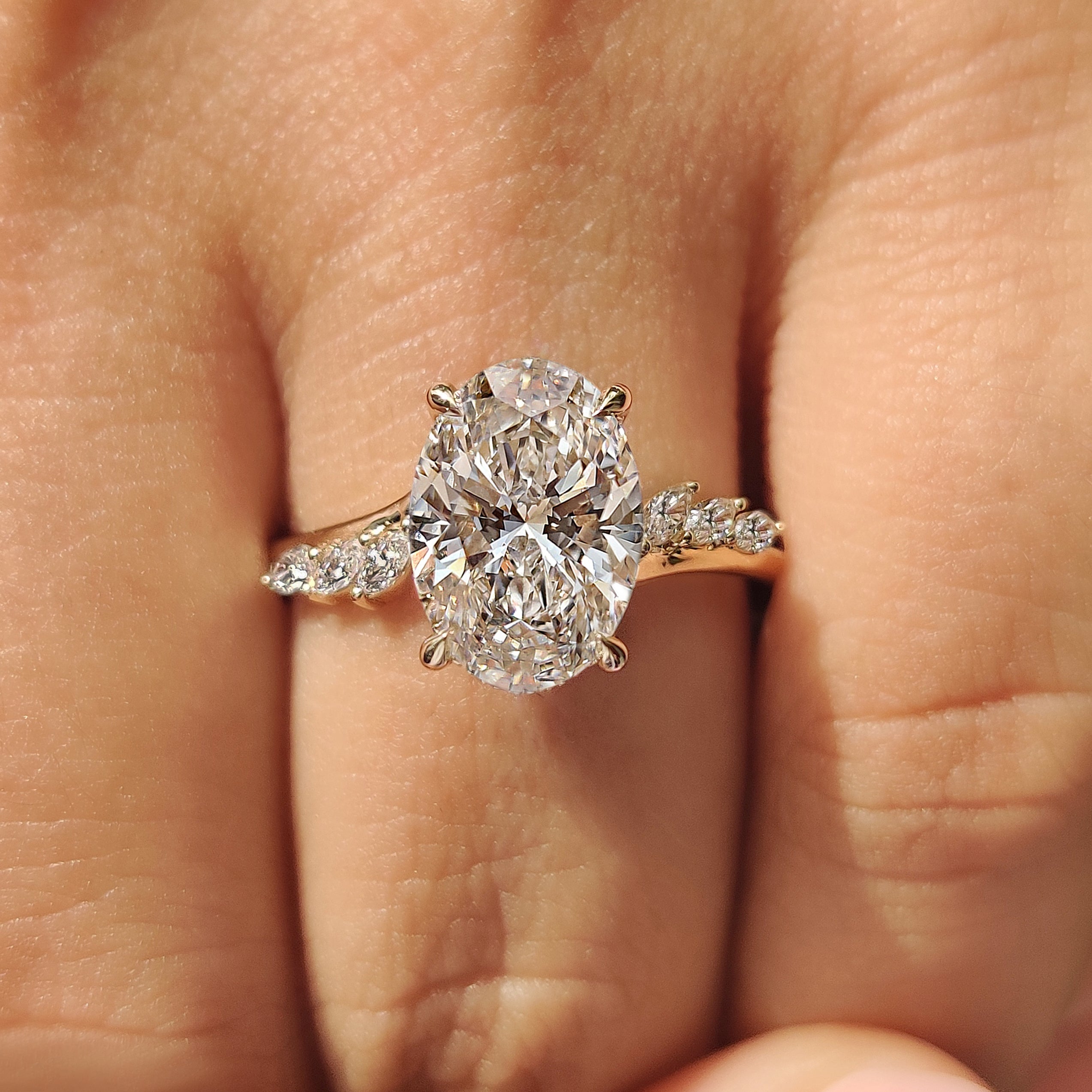 Hidden halo oval diamond ring with round stones.
