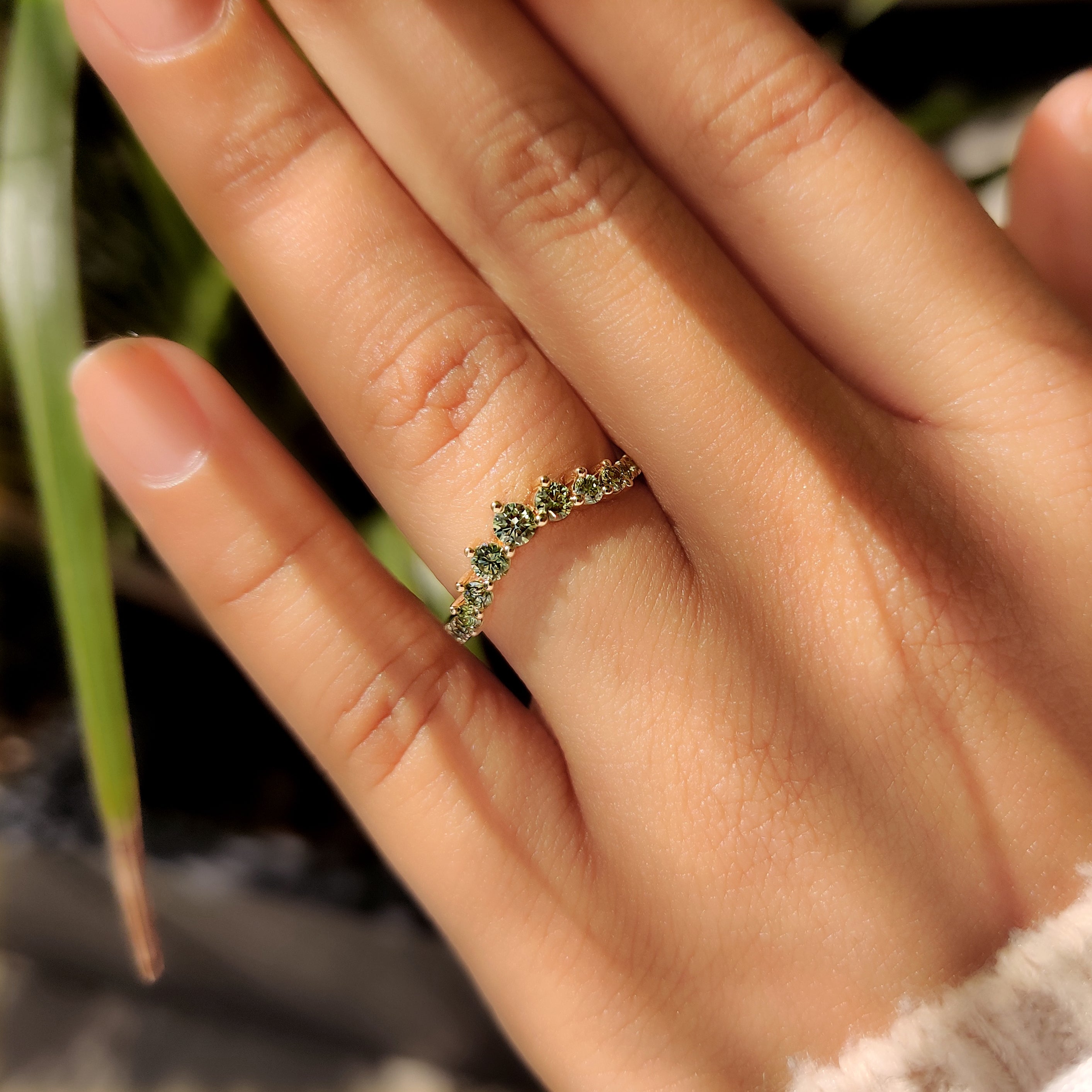 Chevron wedding band with shared prong green diamond setting
