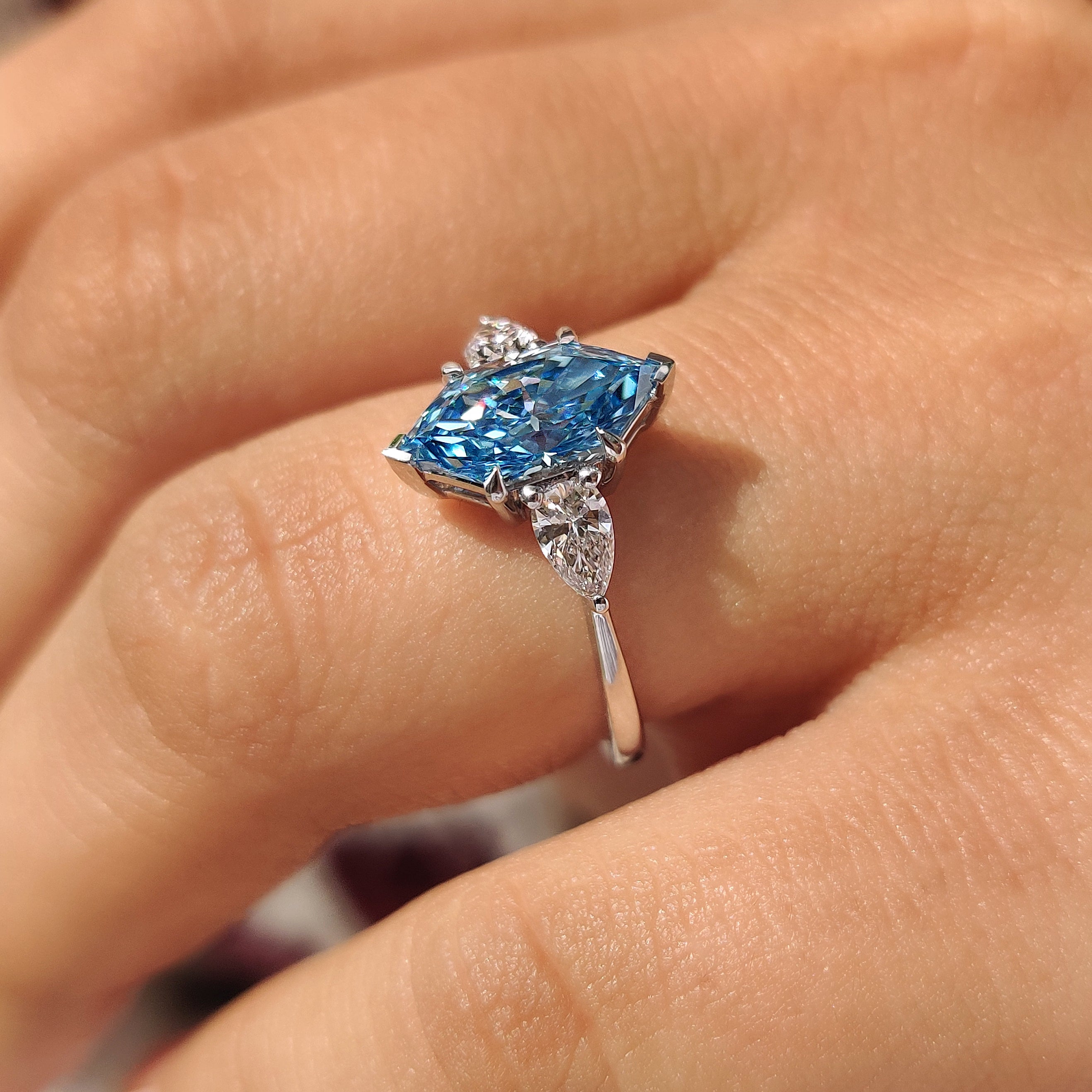 Pear side stones framing blue dutch marquise center diamond
