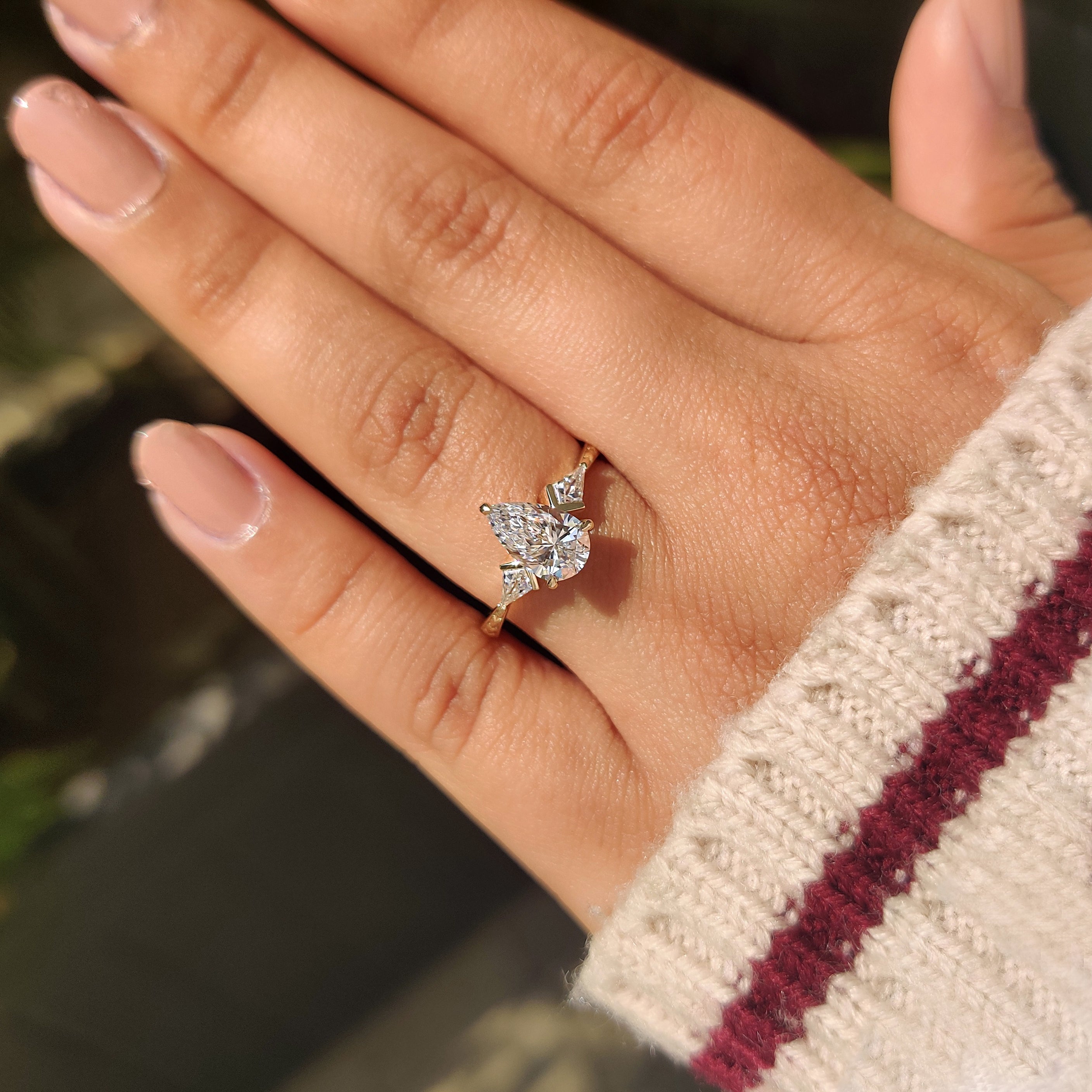 Pear center lab grown diamond ring with kite sides.
