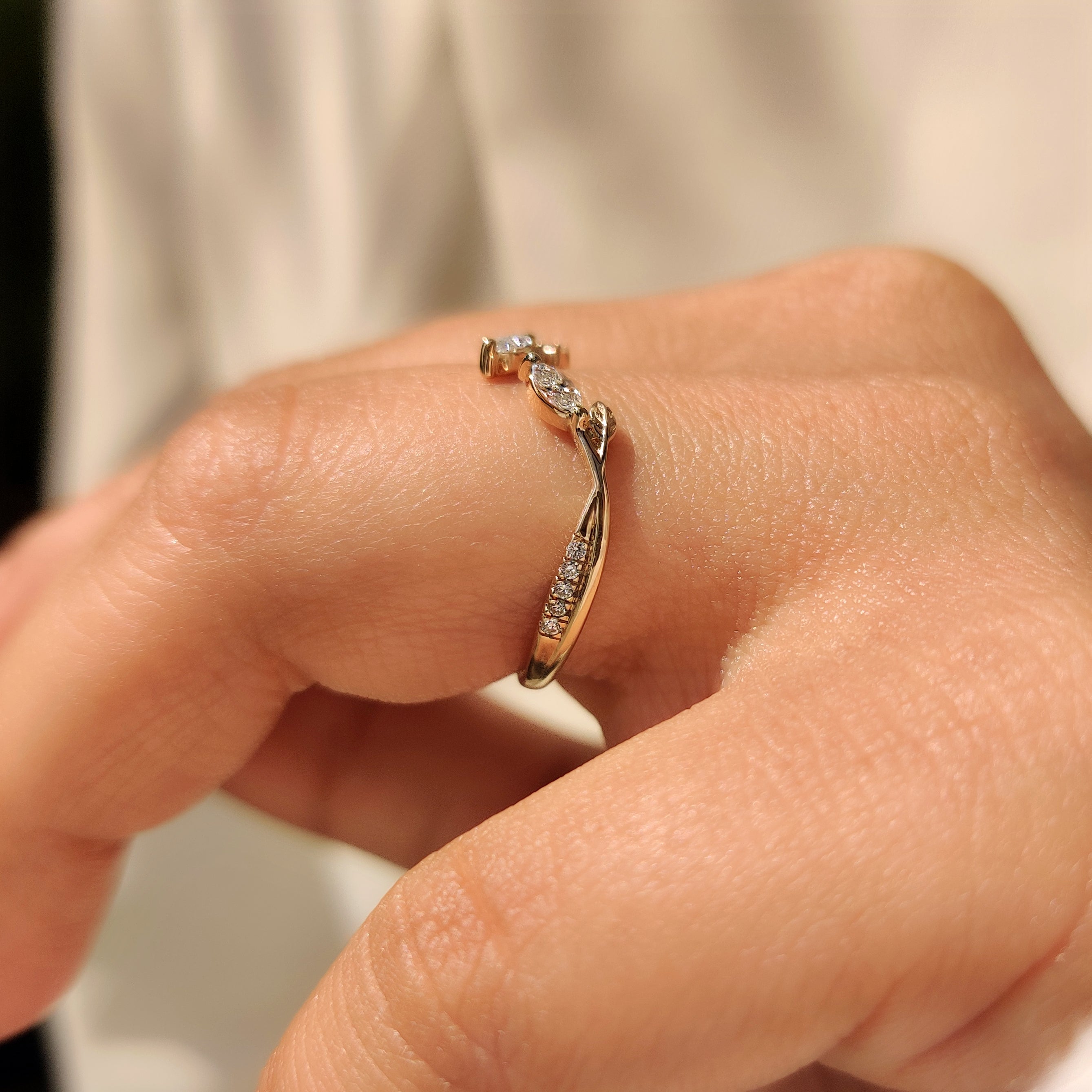 Marquise and round diamond band with leaf detail accents.
