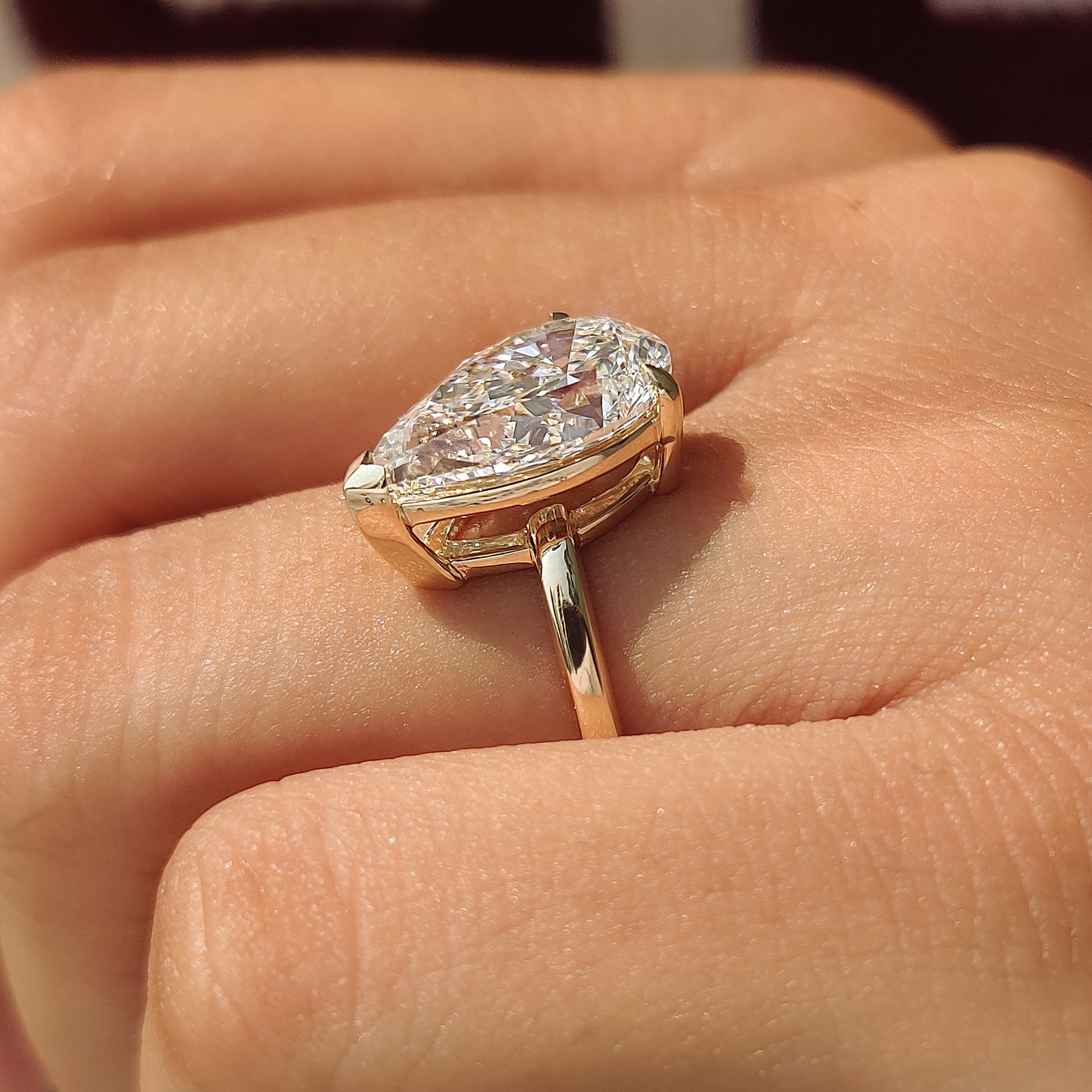 Pear shaped solitaire ring with an open gallery basket.
