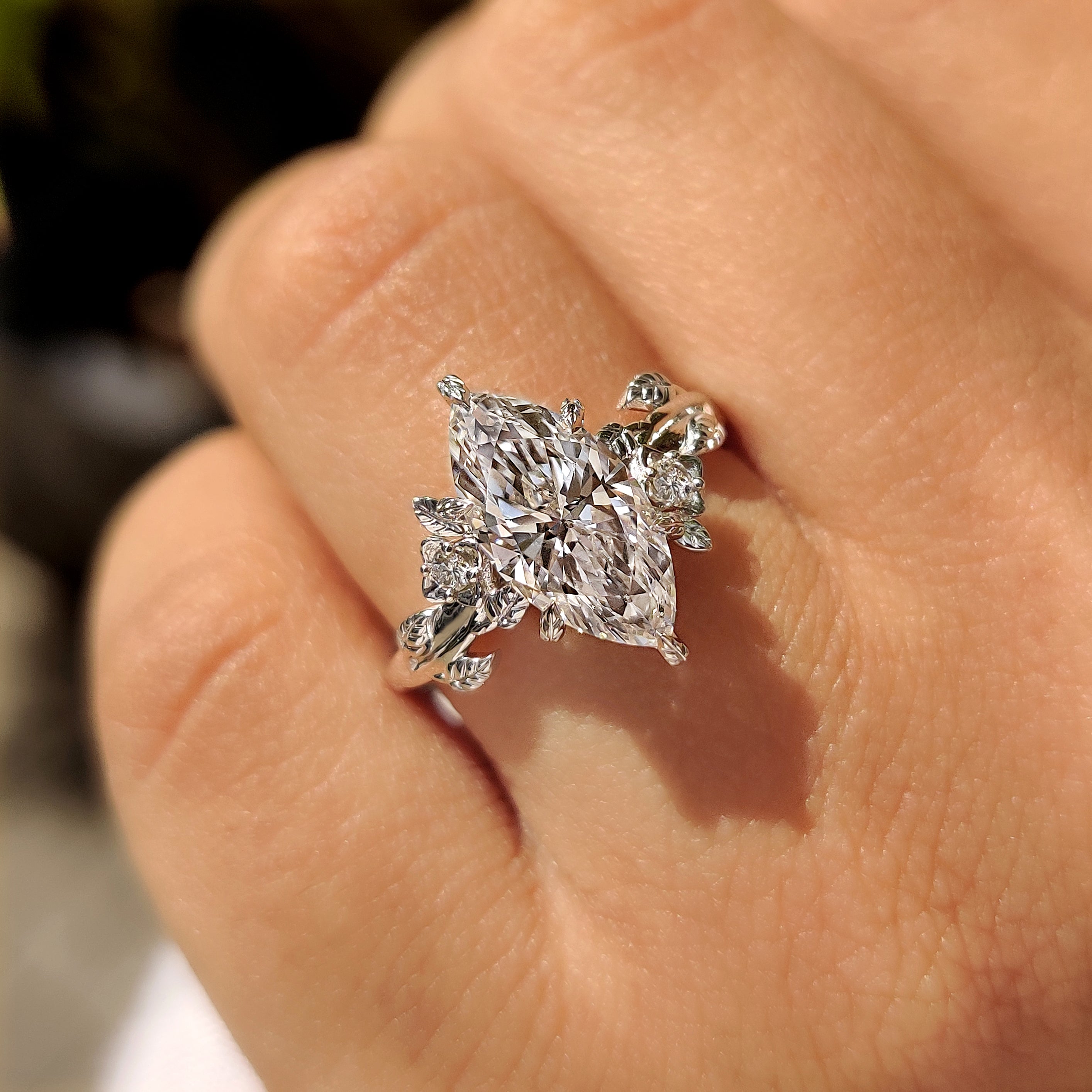 Marquise cut diamond ring with floral and leaf details.
