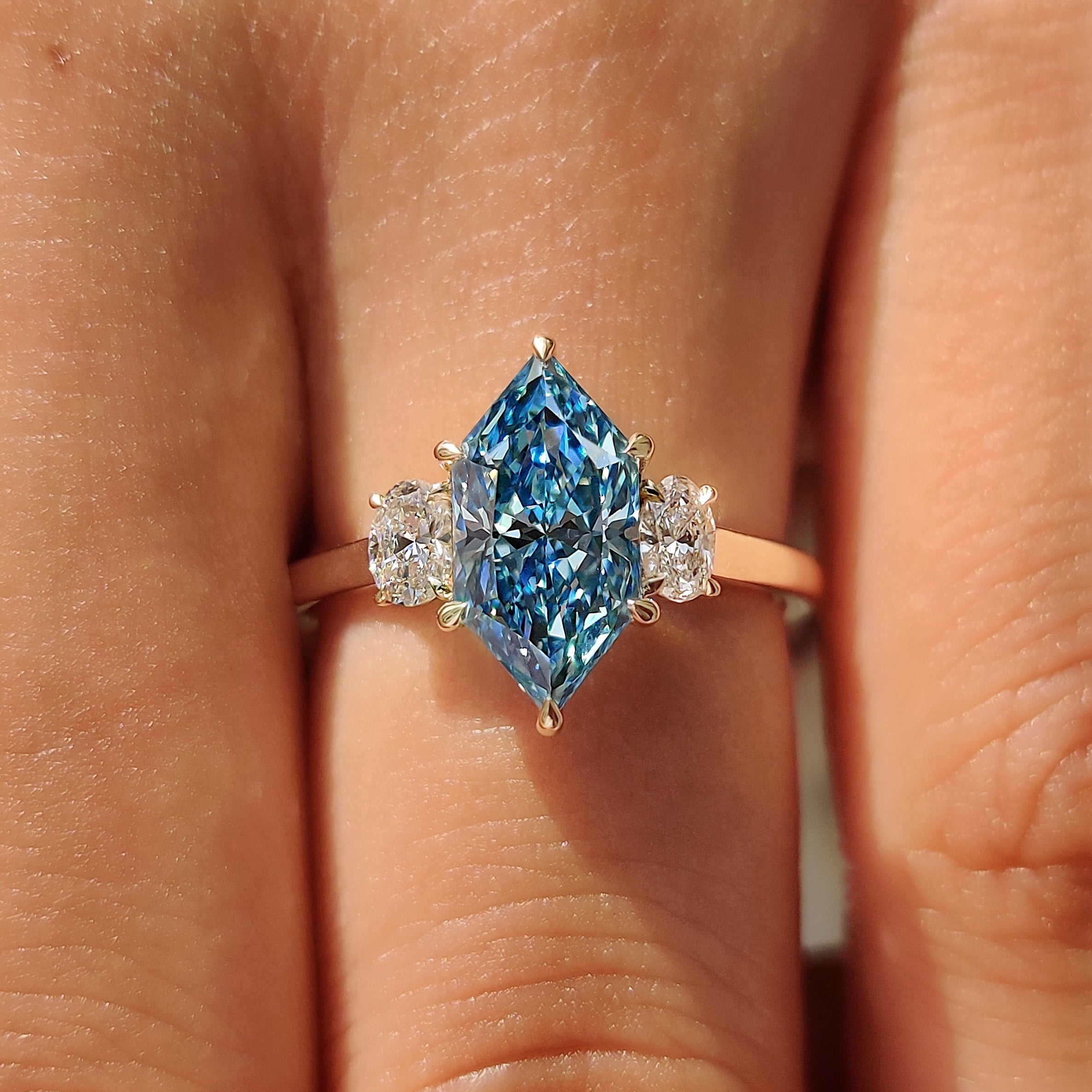 Lab grown blue Dutch marquise trilogy engagement ring.

