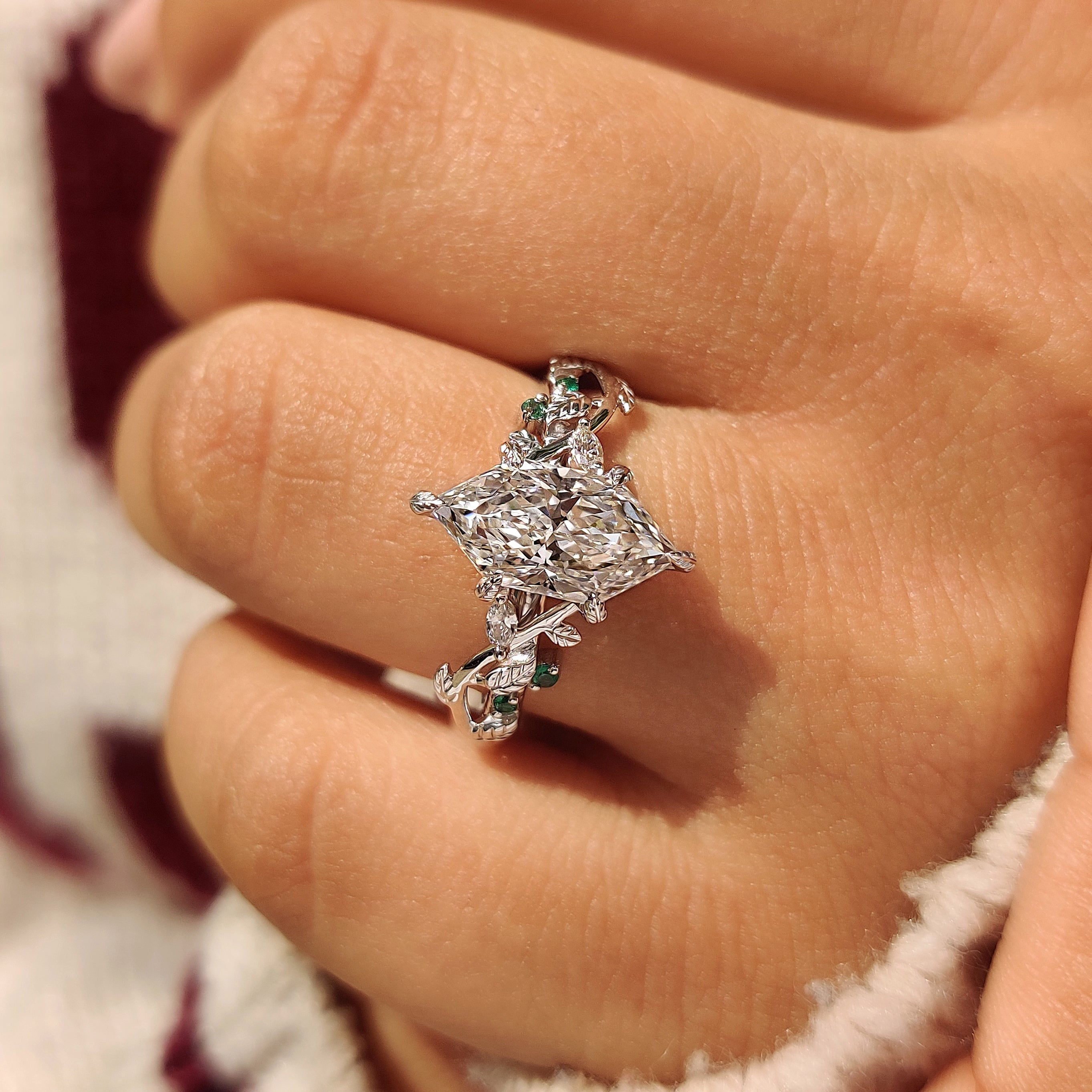 Lab grown diamond ring with light and dark green emeralds
